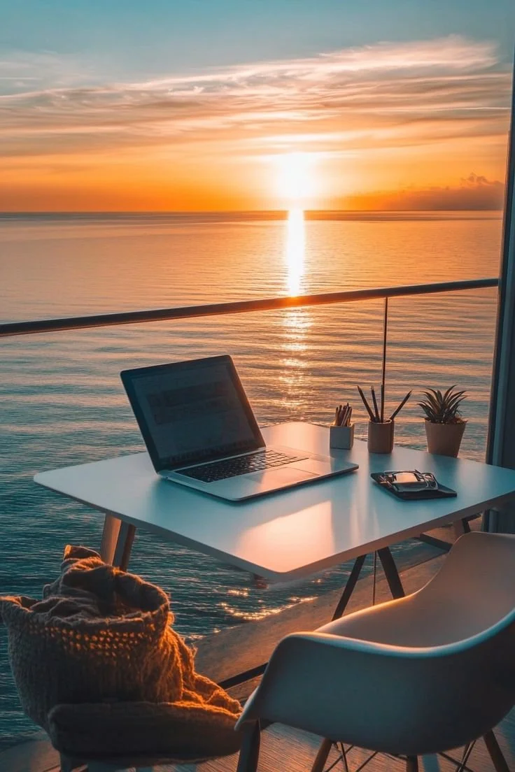 Coaching from anywhere. Laptop on table overlooking the sunset with a ocean view.