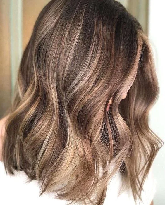 Soft dimensional blonde highlights with loose waves by Inwood Hair Studio in Inwood, New York.