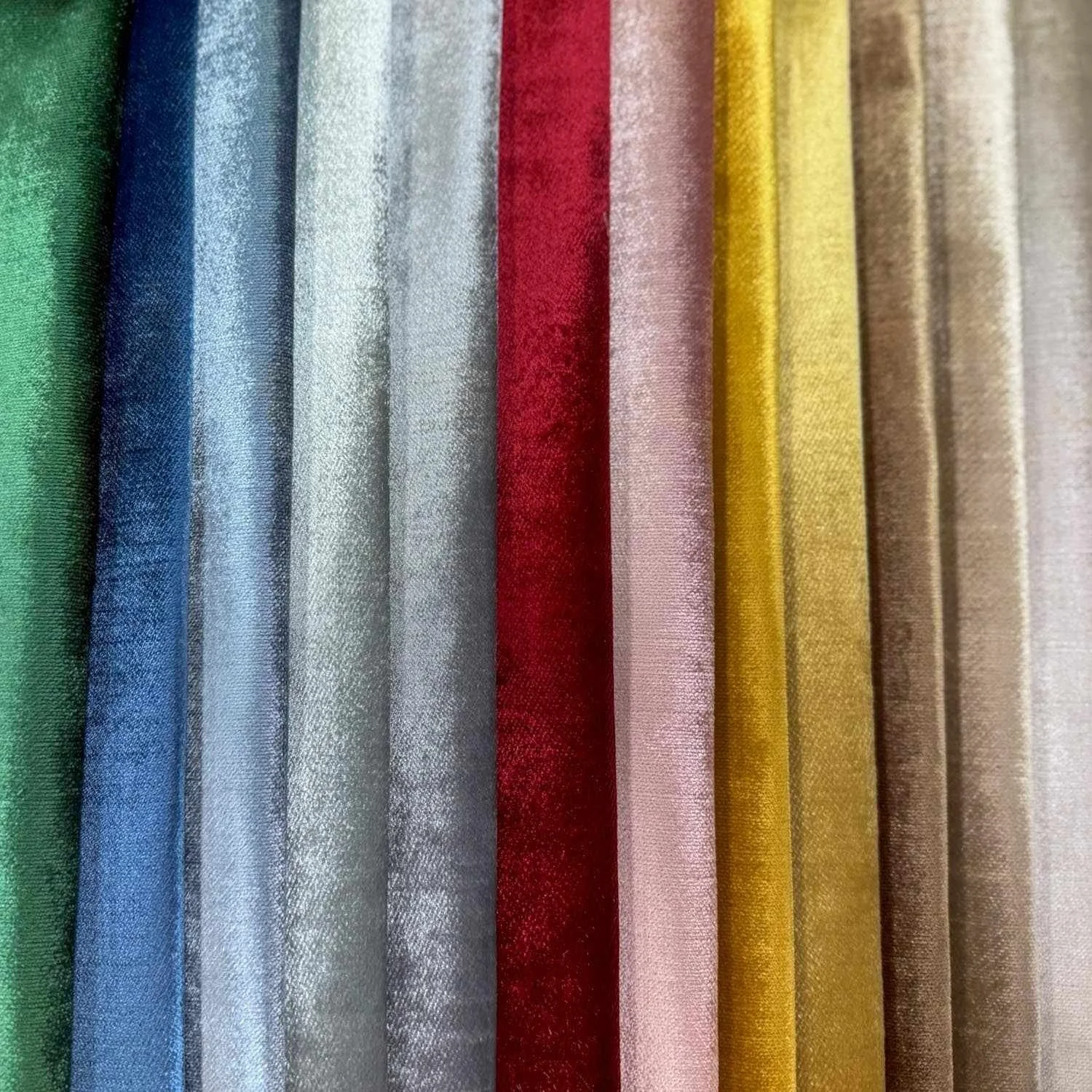 Arranged fabric swatches in various colors including green, blue, silver, red, pink, yellow, and beige.