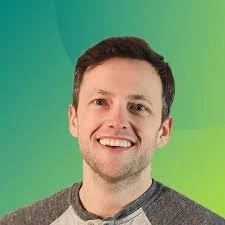 Smiling person with short hair against a green background