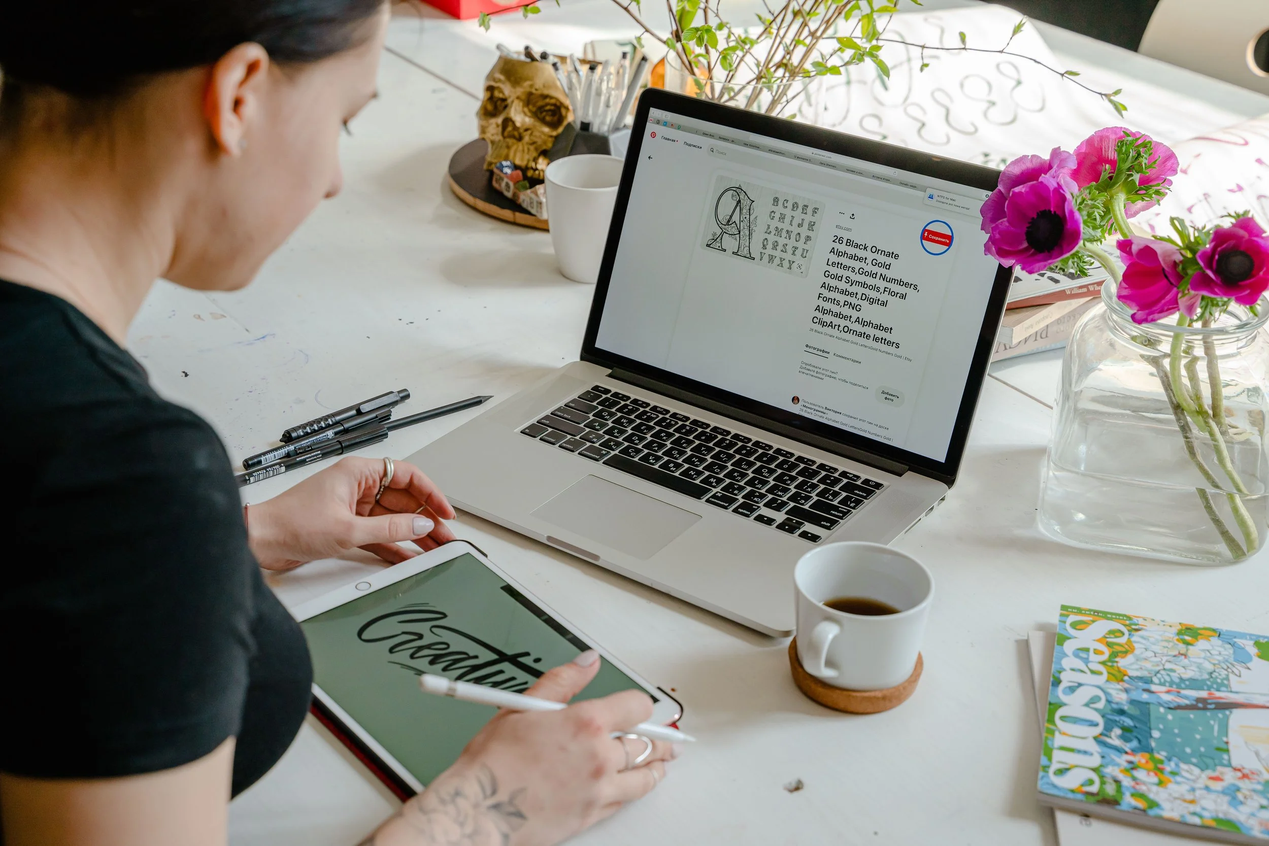 Women sitting at desk holding a stylus pen over a tablet