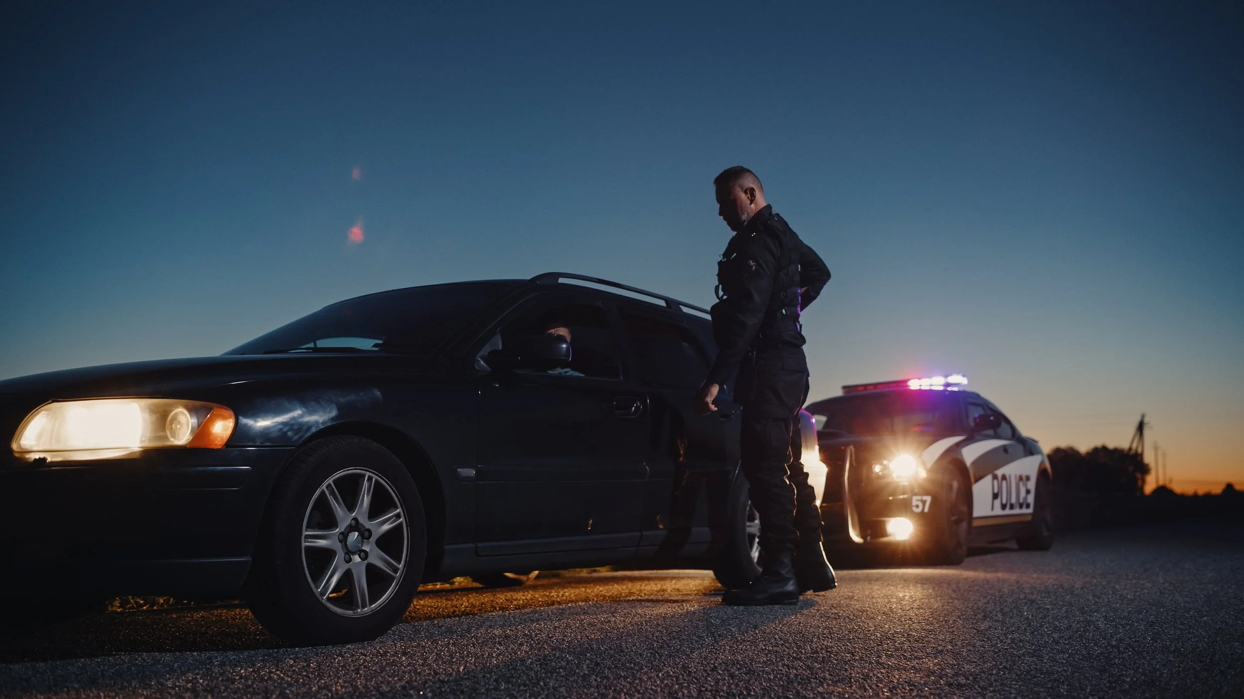 Person speaking with a police officer during a roadside stop