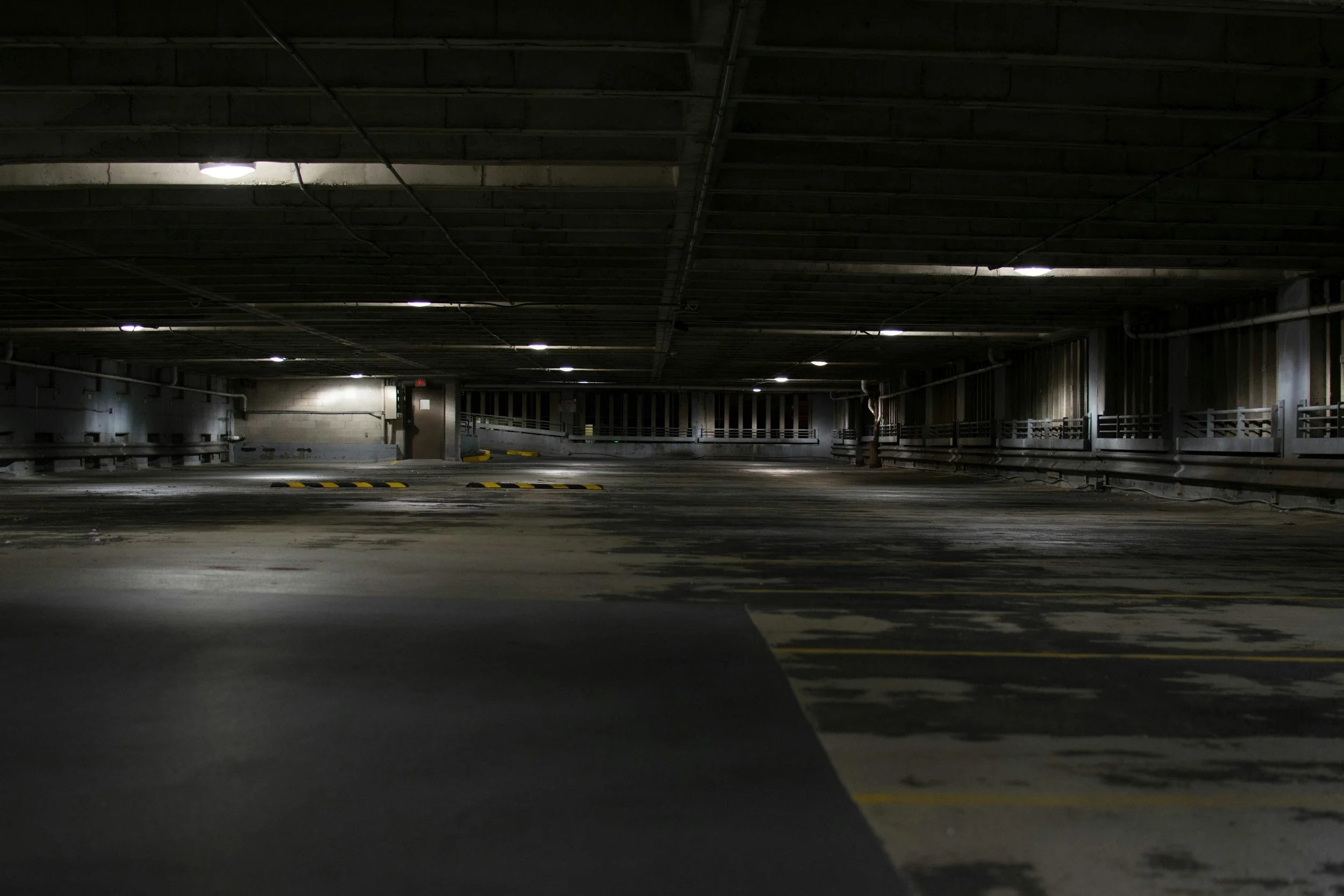 Broken light fixture in a parking garage, an example of a missing security precaution.