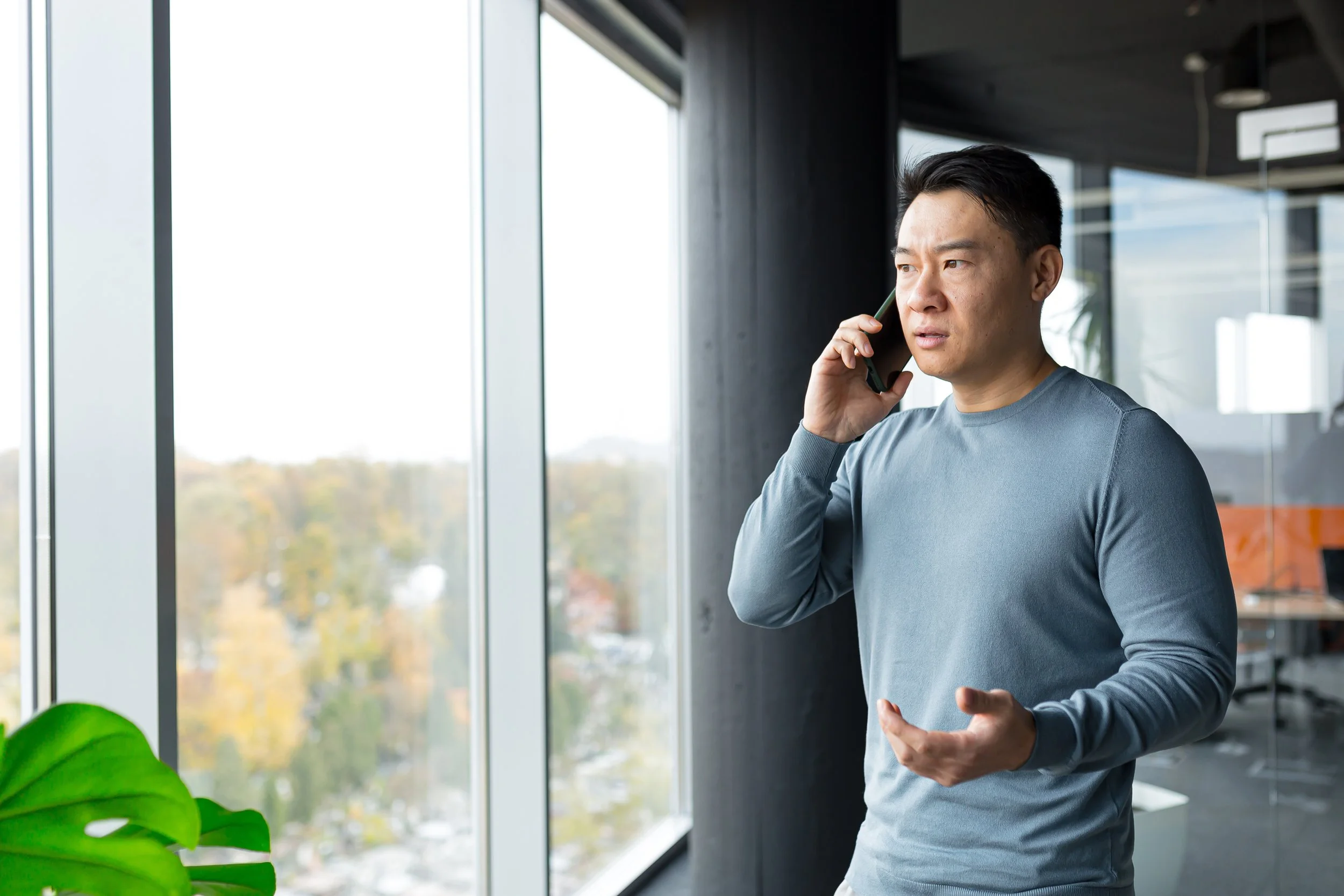 A person taking a phone call from an insurance adjuster while holding accident paperwork.