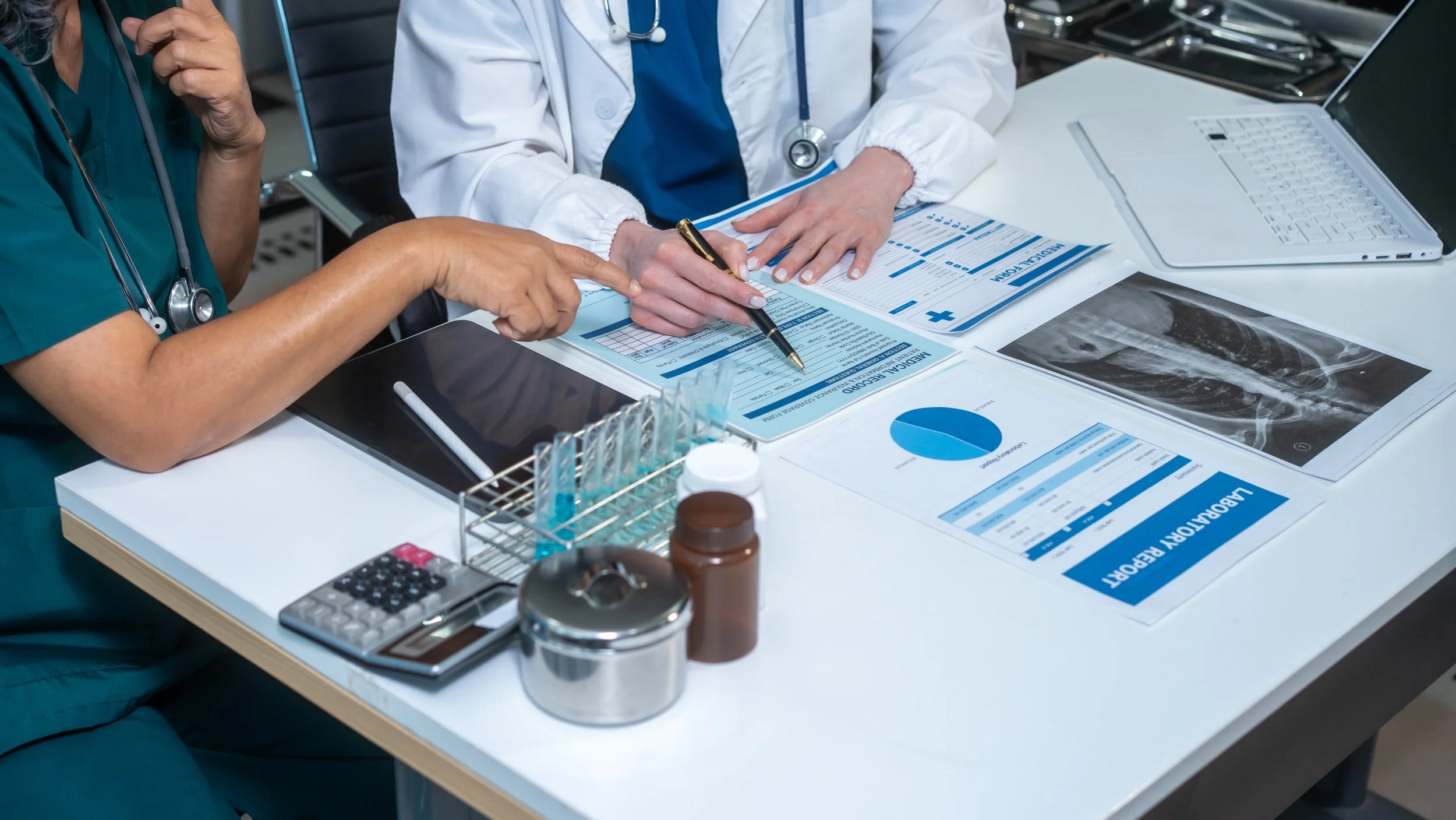 Two medical providers reviewing a case together in a hospital consultation room.