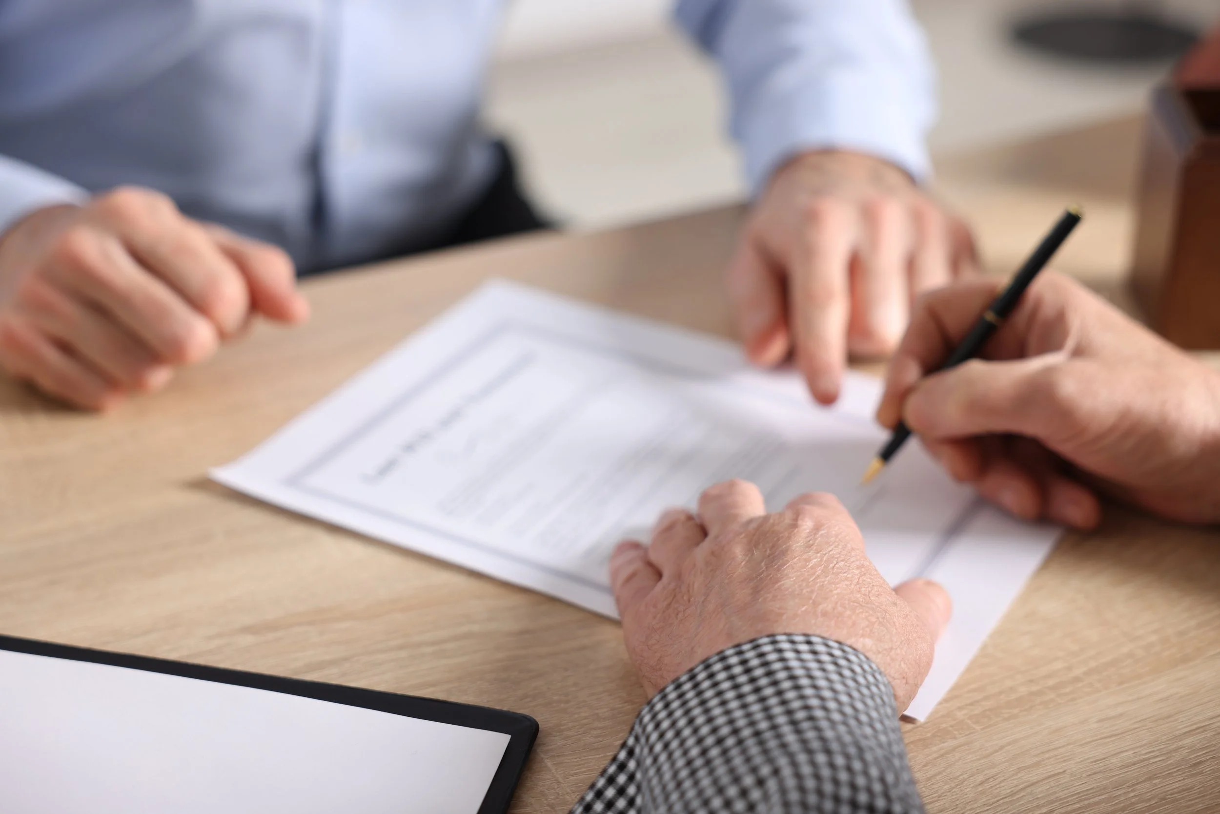 Executor signing legal documents at a desk during estate administration
