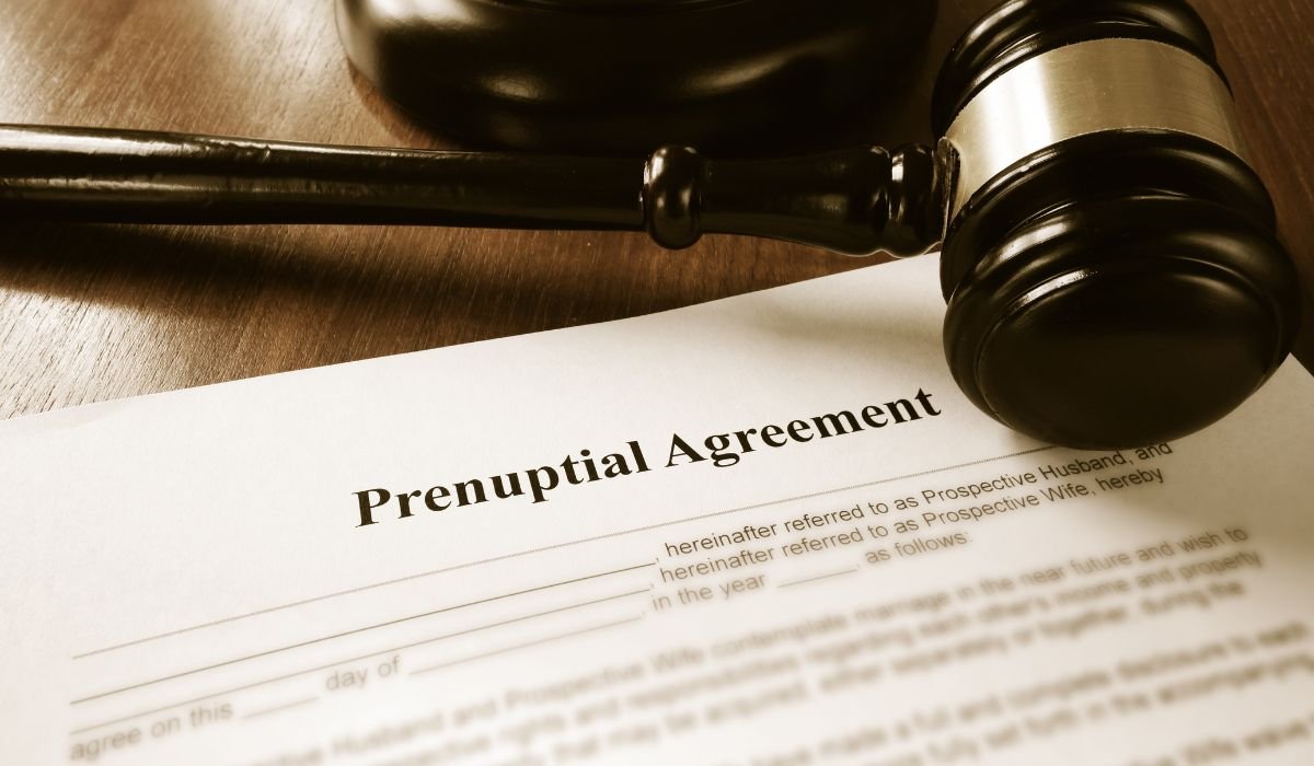 Prenuptial agreement and financial disclosure documents laid out on a desk