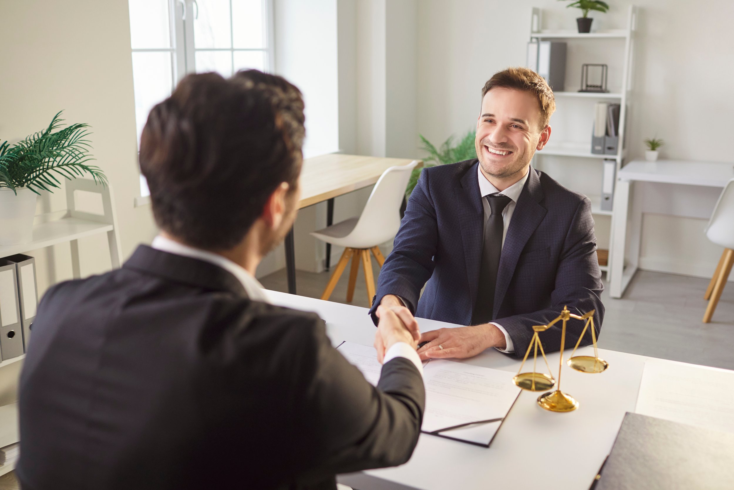 Attorney shaking hands with a new client at the start of a legal consultation