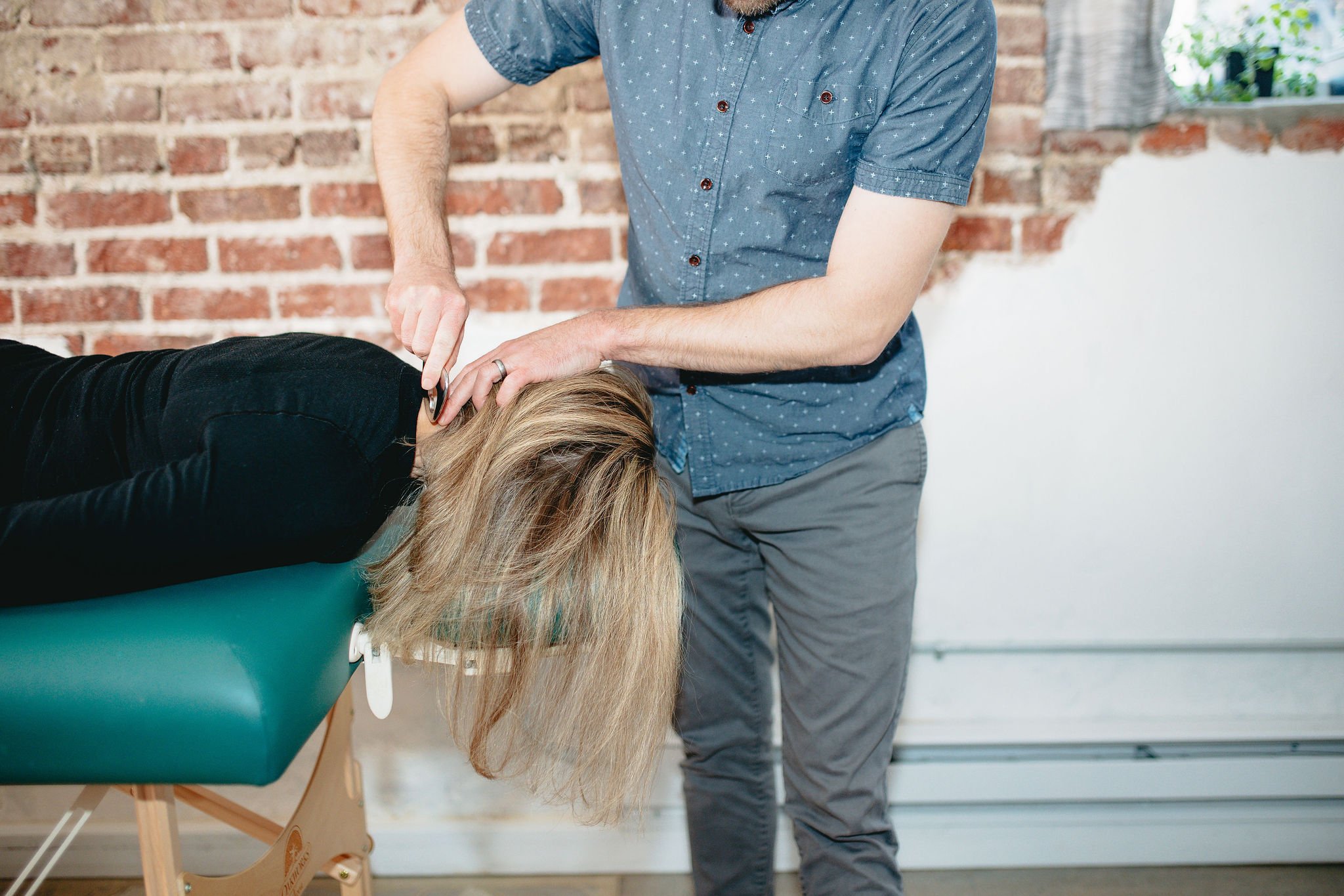 Physical therapist, Dr. Corey Hillman, applies manual therapy technique to patient's neck