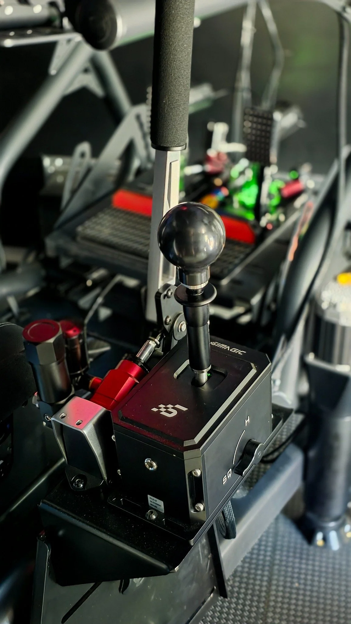 Simagic shifter and handbrake beside a Turn 6 simulator seat.