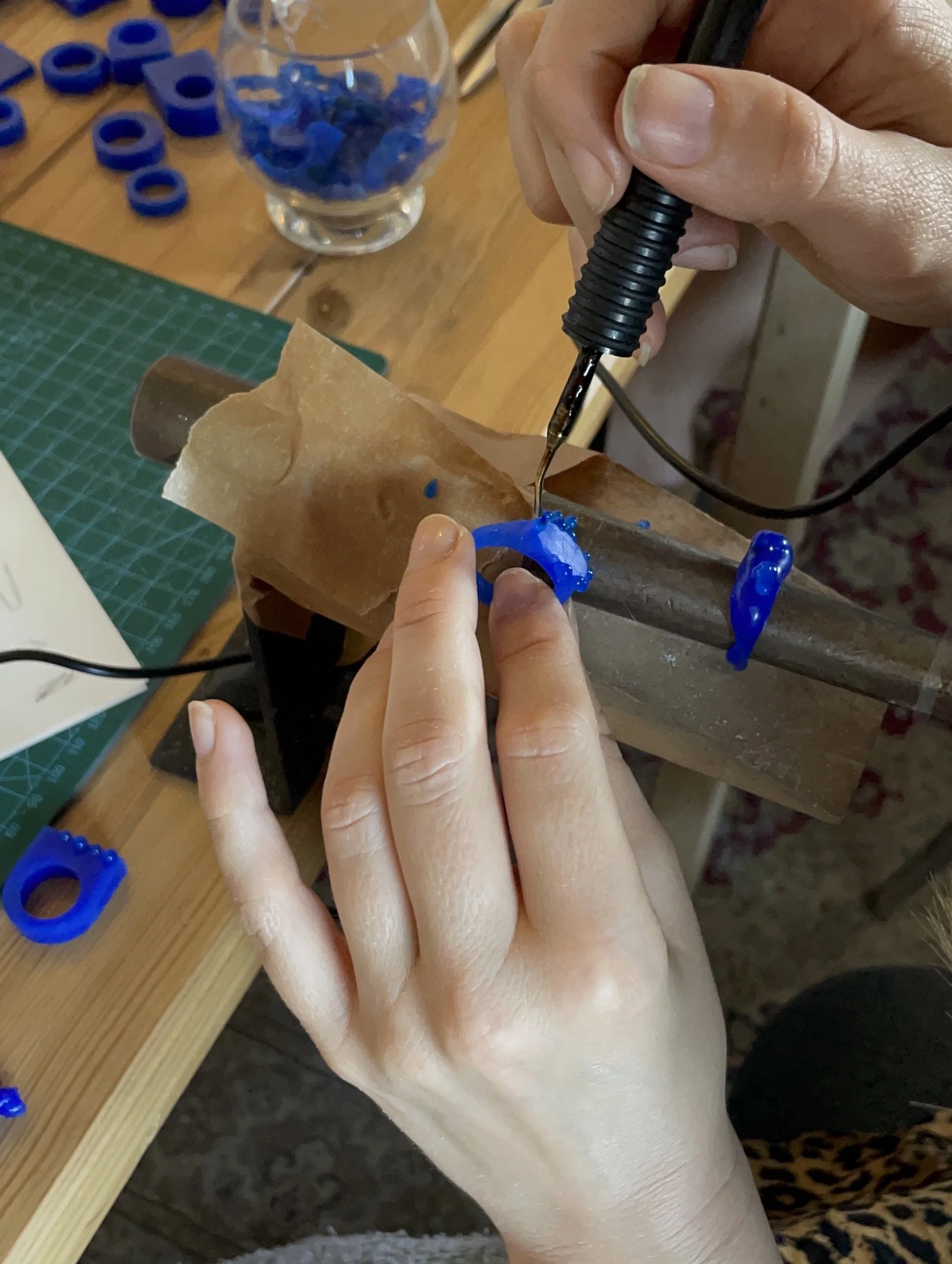 Person designing jewelry wax to craft a wax model using a hot wax pen during a DIY lost wax casting jewelry workshop in Köln.