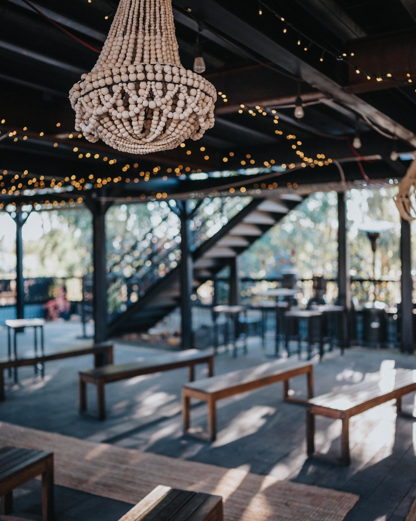King Road Brewery has multiple ceremony locations onsite! This setup under the lights is a perfect &ldquo;any weather&rdquo; option for your guests. Using their benches to line the aisle 👌