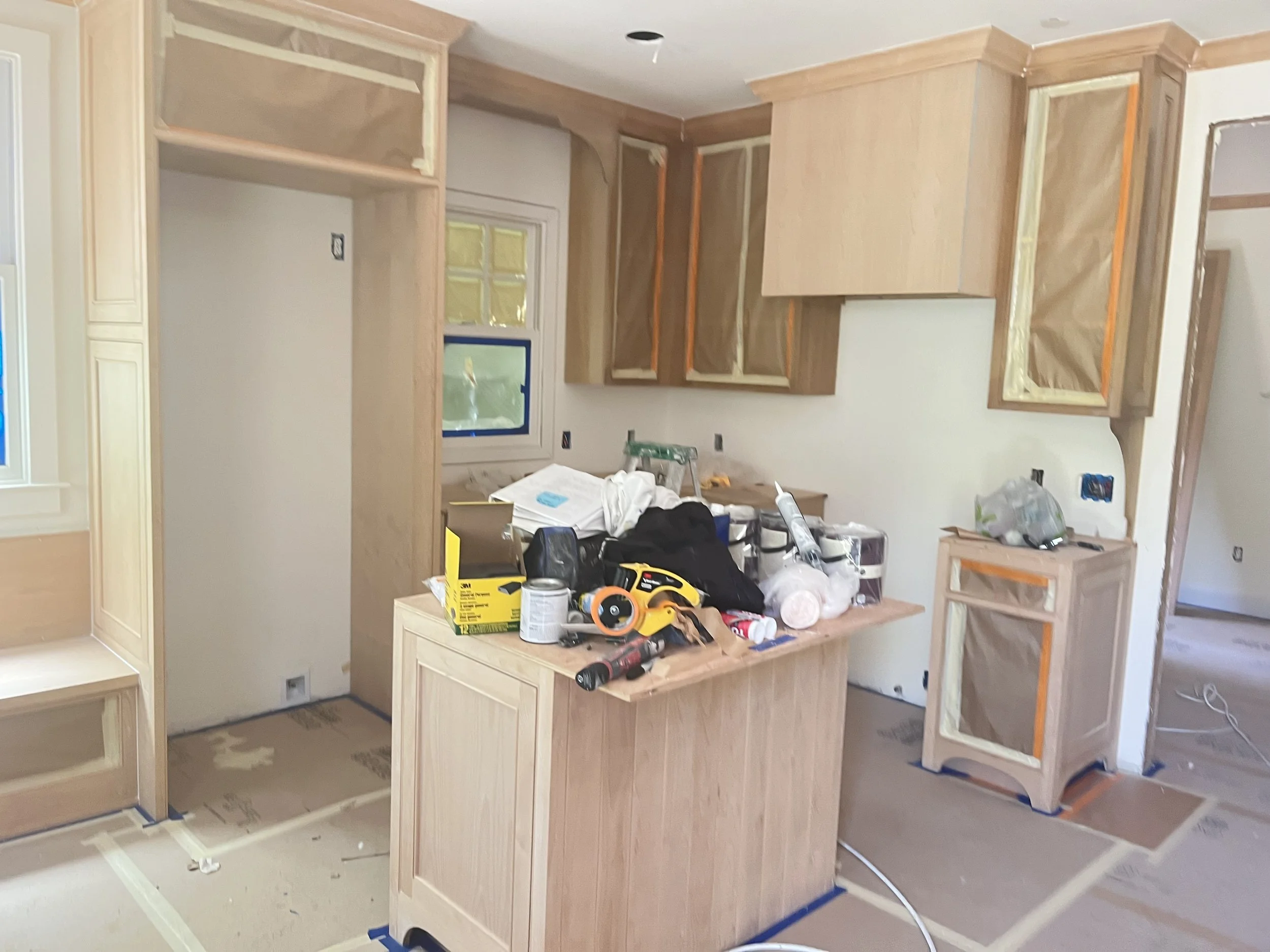 Kitchen in construction with unfinished cabinetry and tools on island