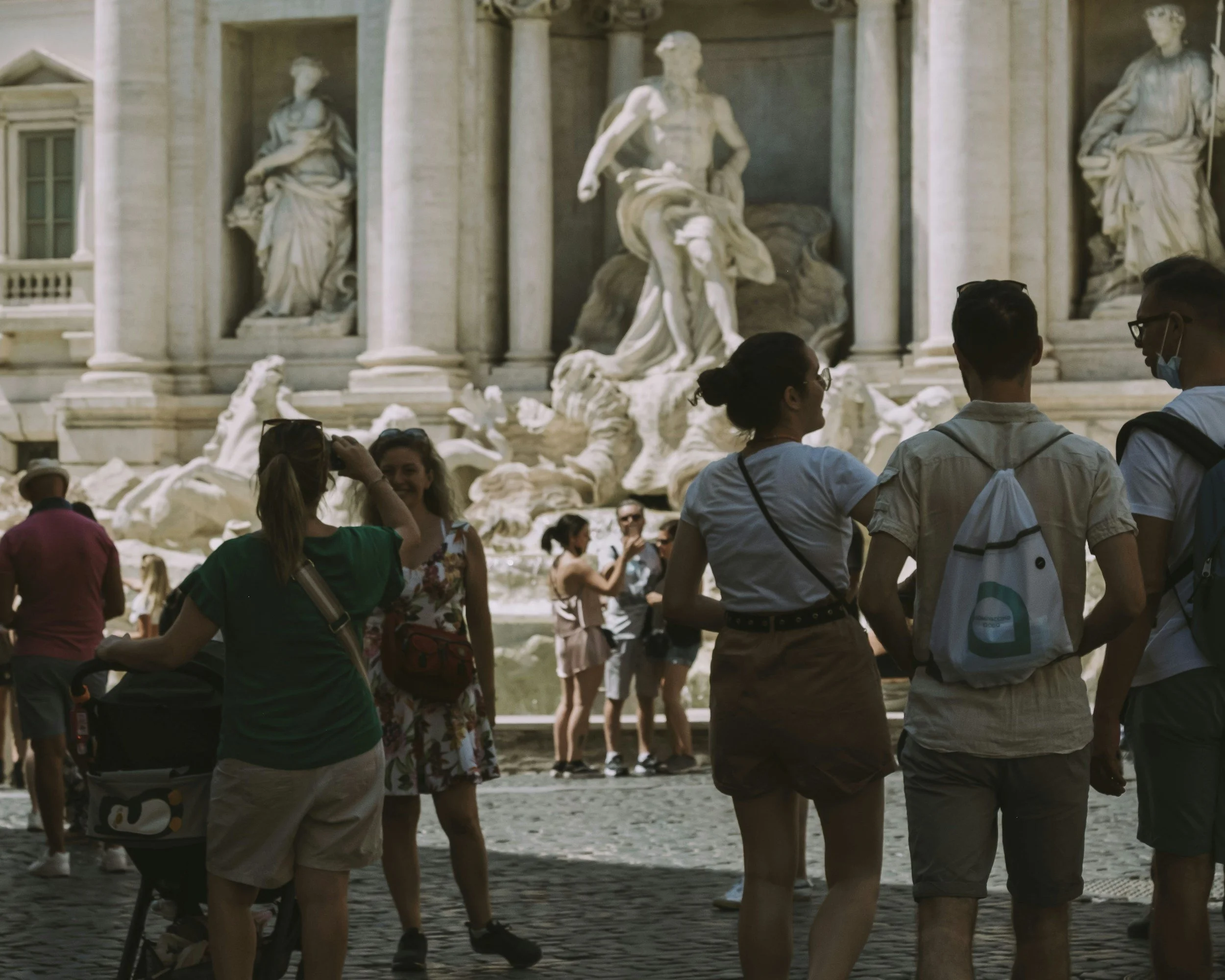 Tourists sightseeing in front of the Trevi Fountain in Rome, Italy.