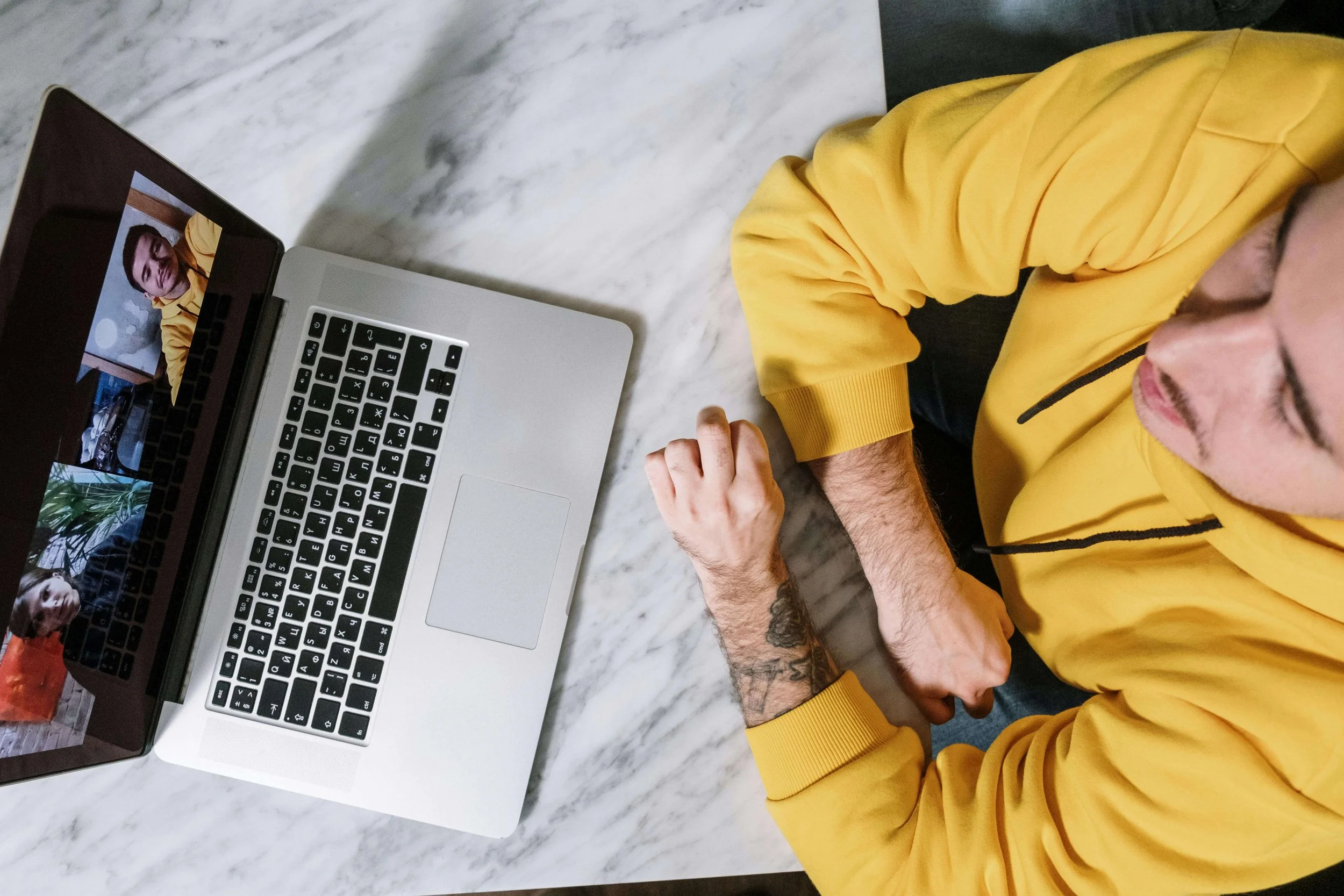 Person in yellow sweatshirt participating in virtual therapy session on laptop. Get judgment-free support for marijuana use through convenient virtual SAP evaluations in Las Vegas, NV.
