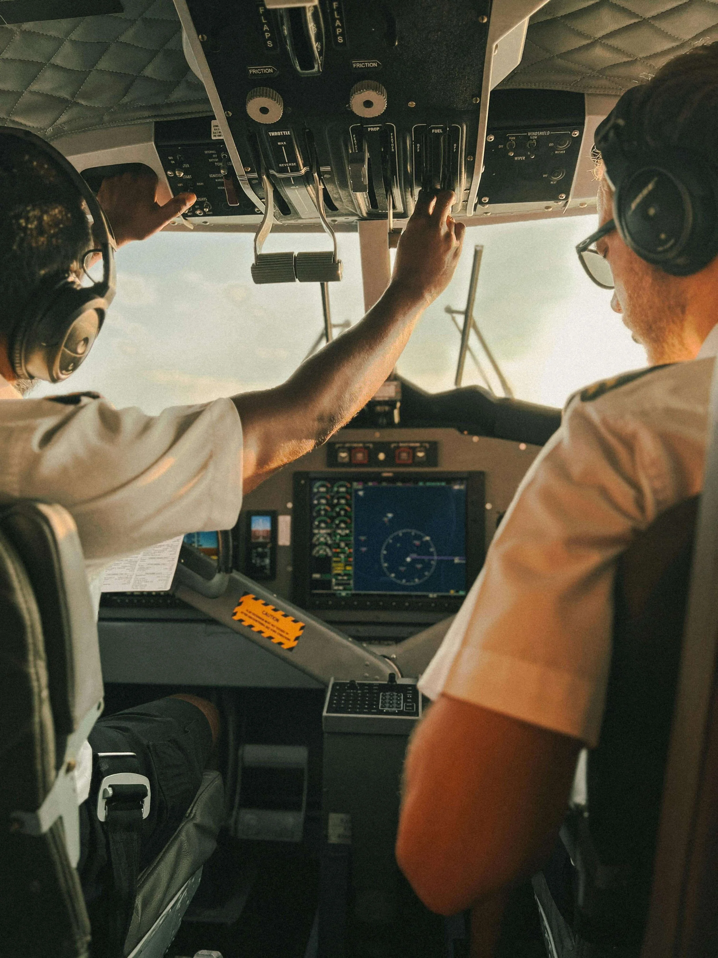 Two pilots working together at overhead controls in aircraft cockpit. Restore your aviation career with comprehensive SAP Evaluations in Las Vegas, NV designed for FAA compliance.