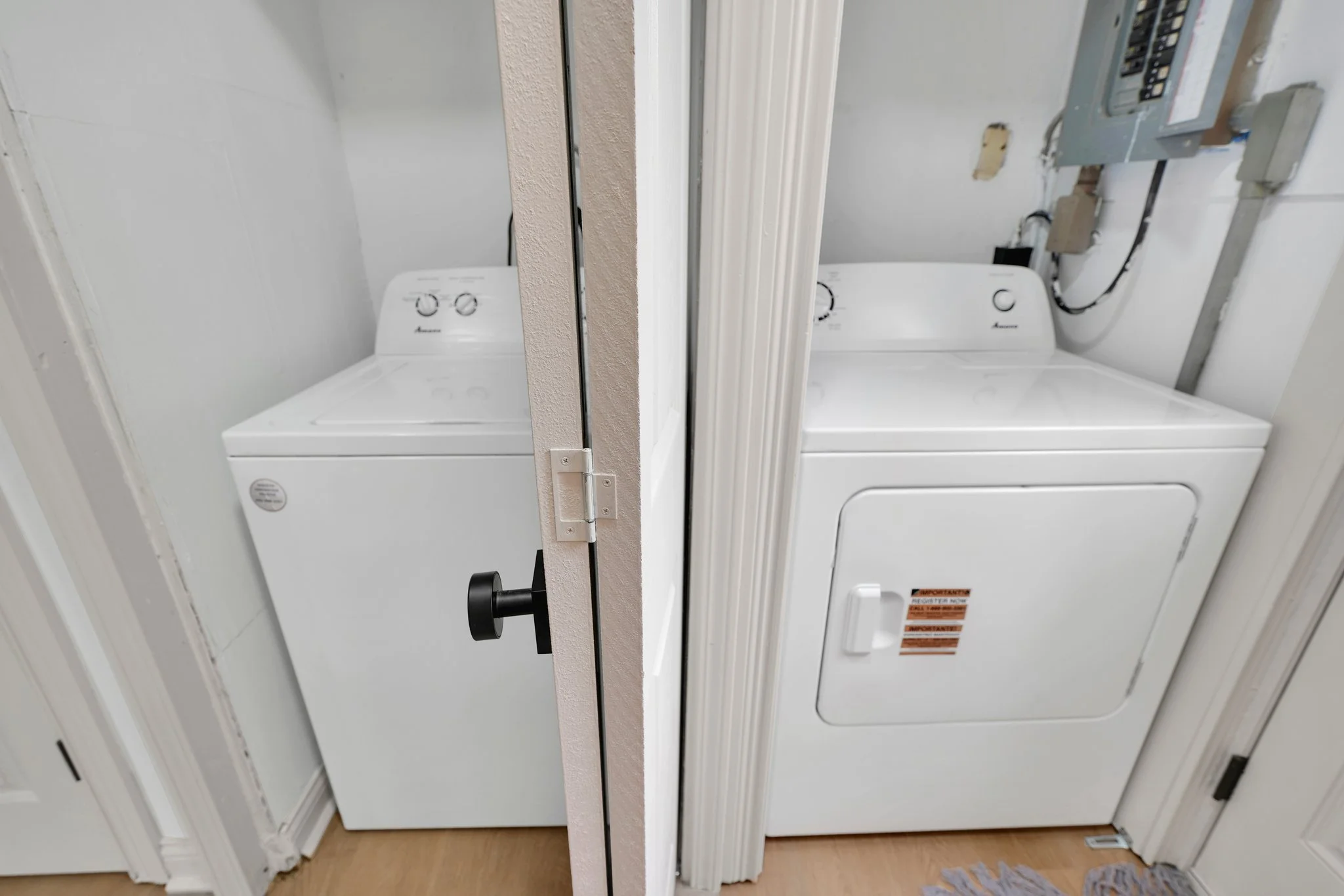 Side-by-side comparison of a white top-loading washing machine on the left and a white front-loading dryer on the right, located in a laundry area.