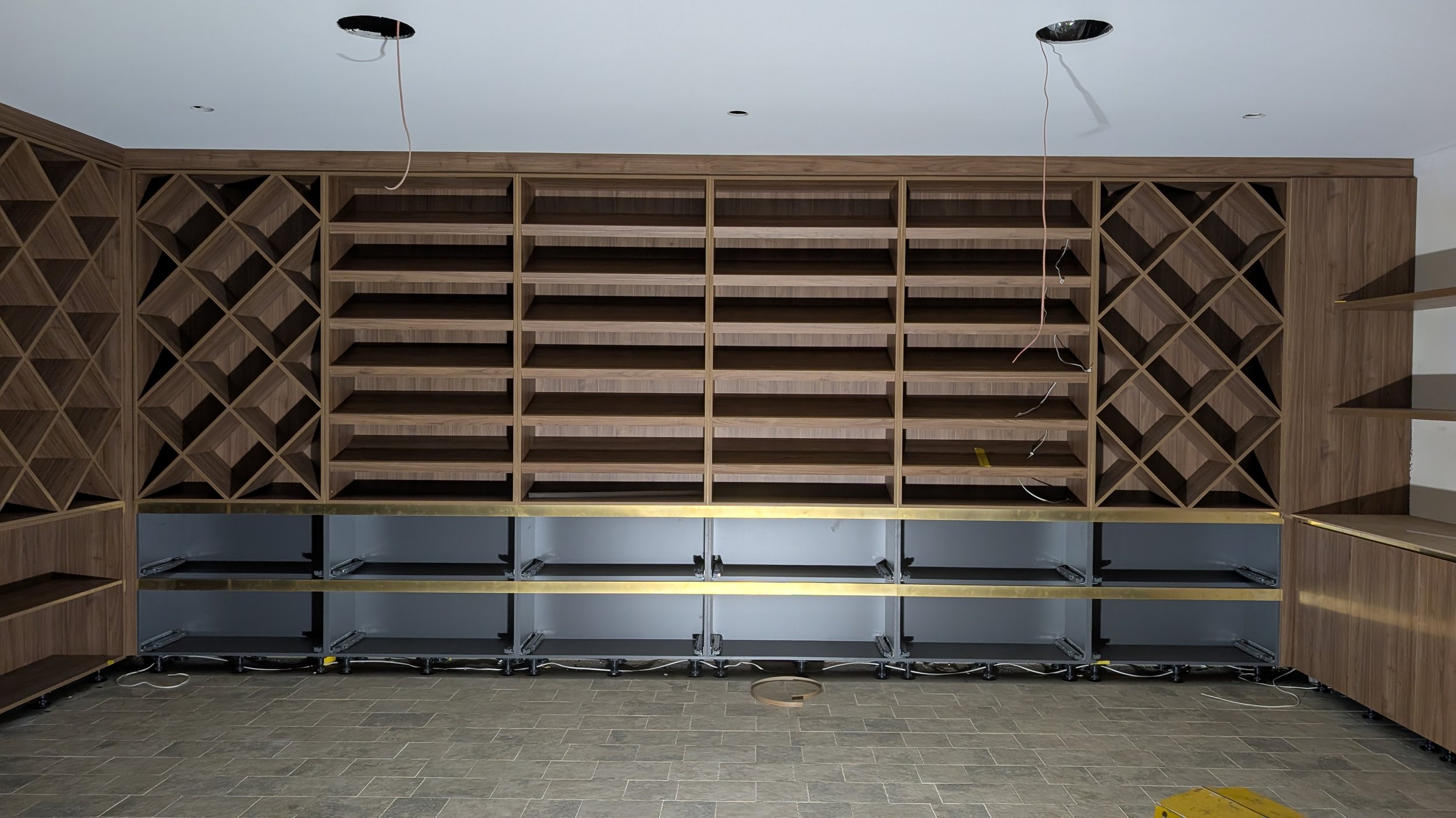 Wooden shelves and wine racks under construction in a room.