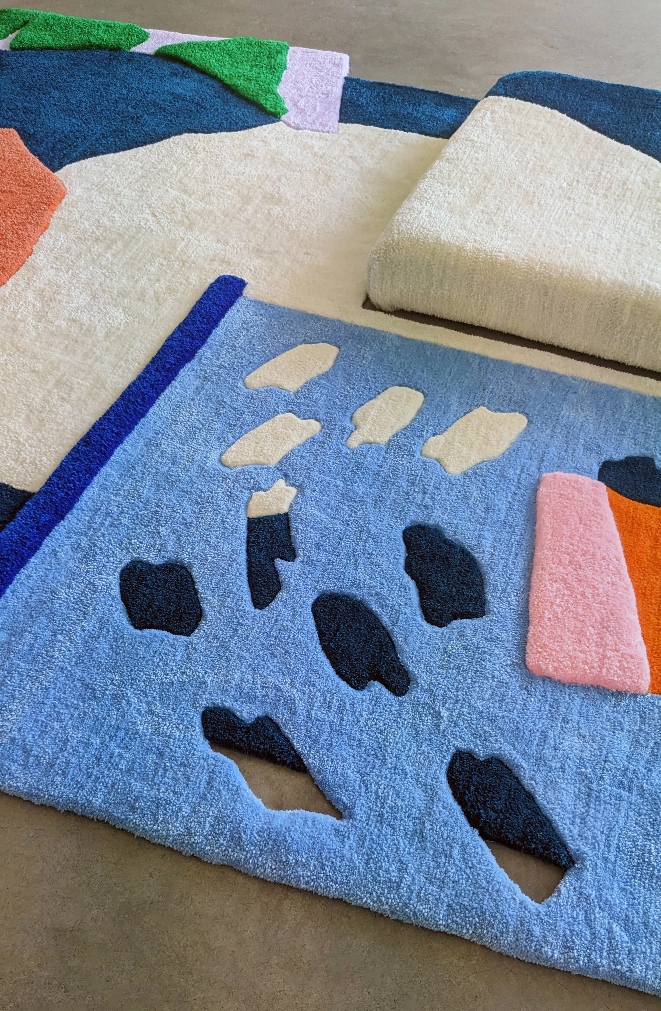 Close-up of a tufted textile art rug showing cut-outs and carved textures.