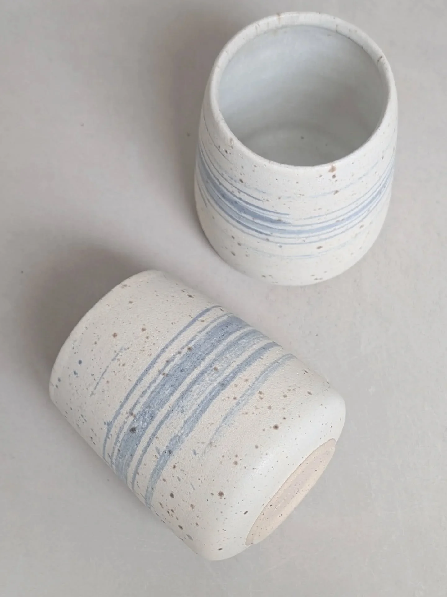 Two lil' breakers in off-white matt glaze with cobalt brush strokes. These make me think of sea spray on a windy day 🌊 

Annoyingly one of these has a glaze fault inside 🥲 from what looks like a bristle from the brush I stir my glaze with that must
