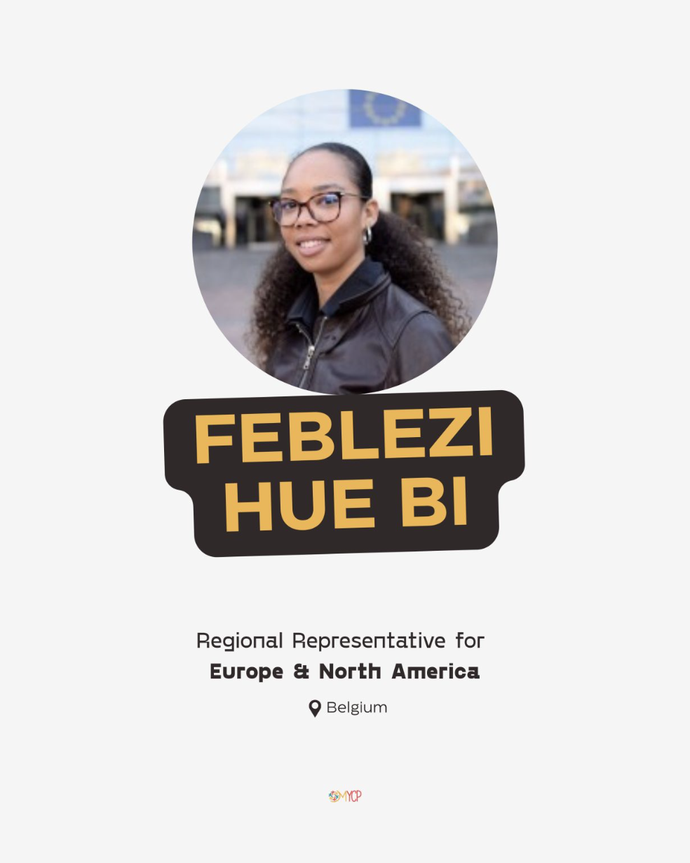 A woman with glasses and curly hair, wearing a black jacket, standing outdoors with a blurred background featuring a European Union flag, accompanied by text indicating her name and regional representative role for Europe and North America, based in Belgium.