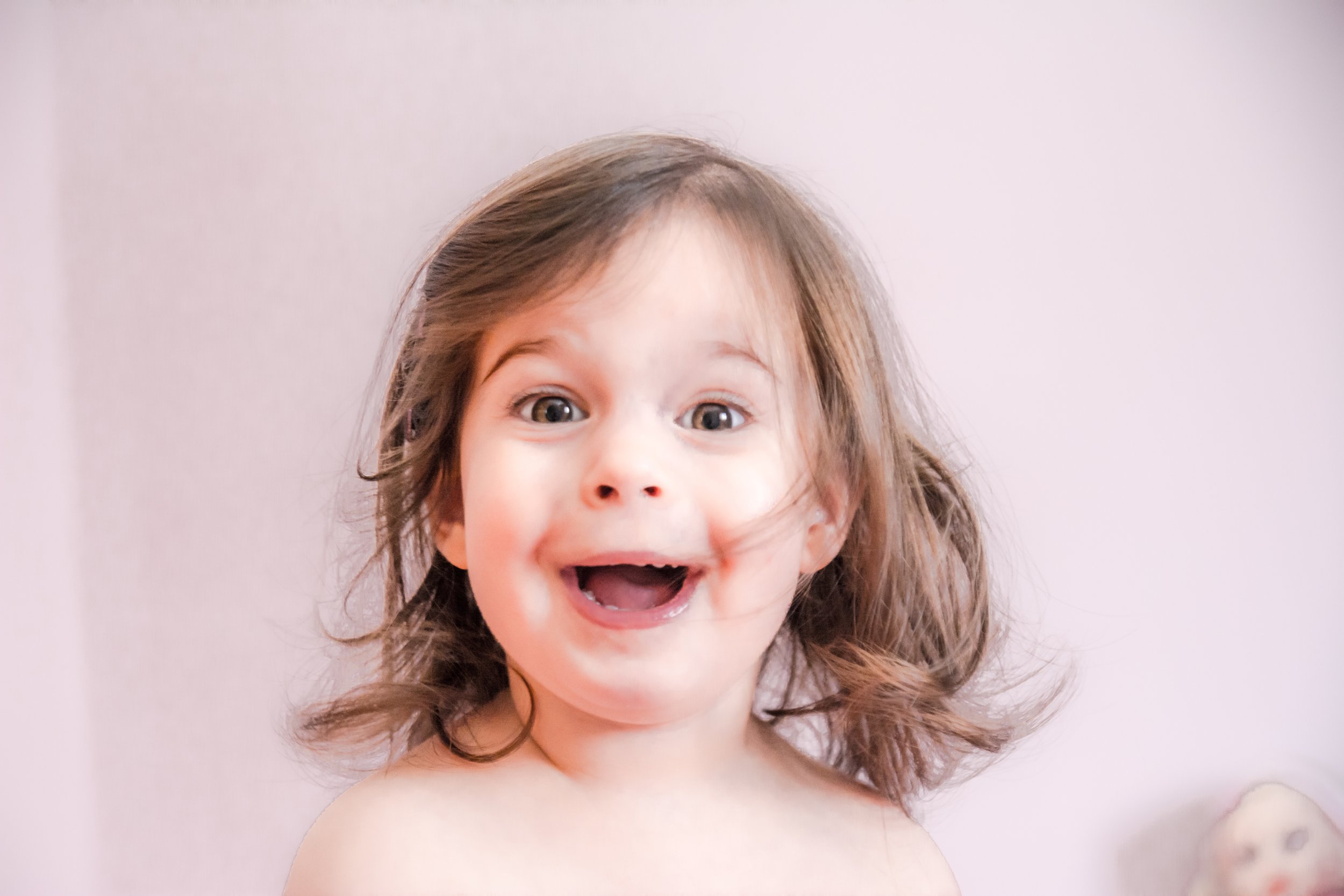 Happy child with surprised expression and tousled hair.