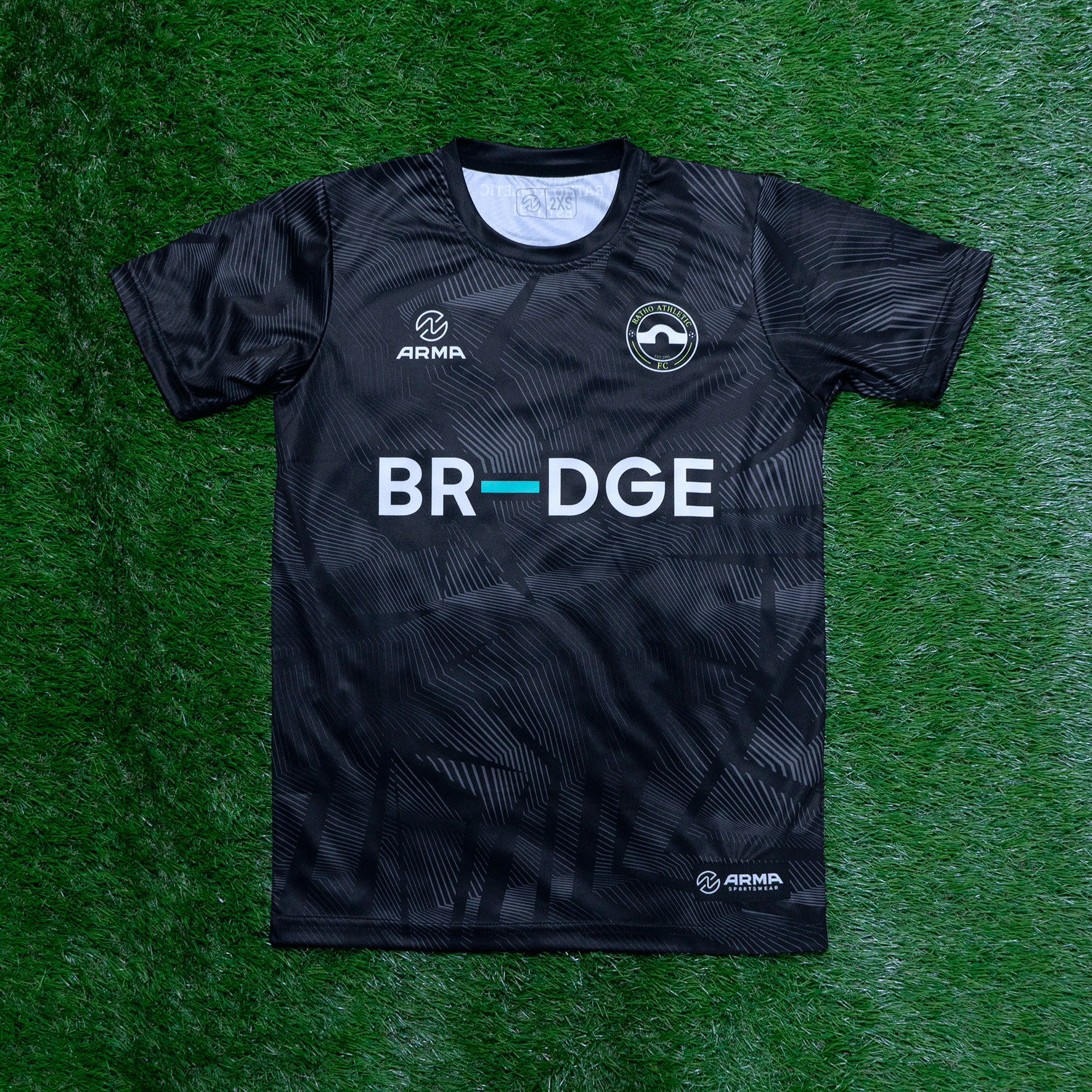 Black athletic jersey with geometric pattern, featuring logos for ARMA Sportswear