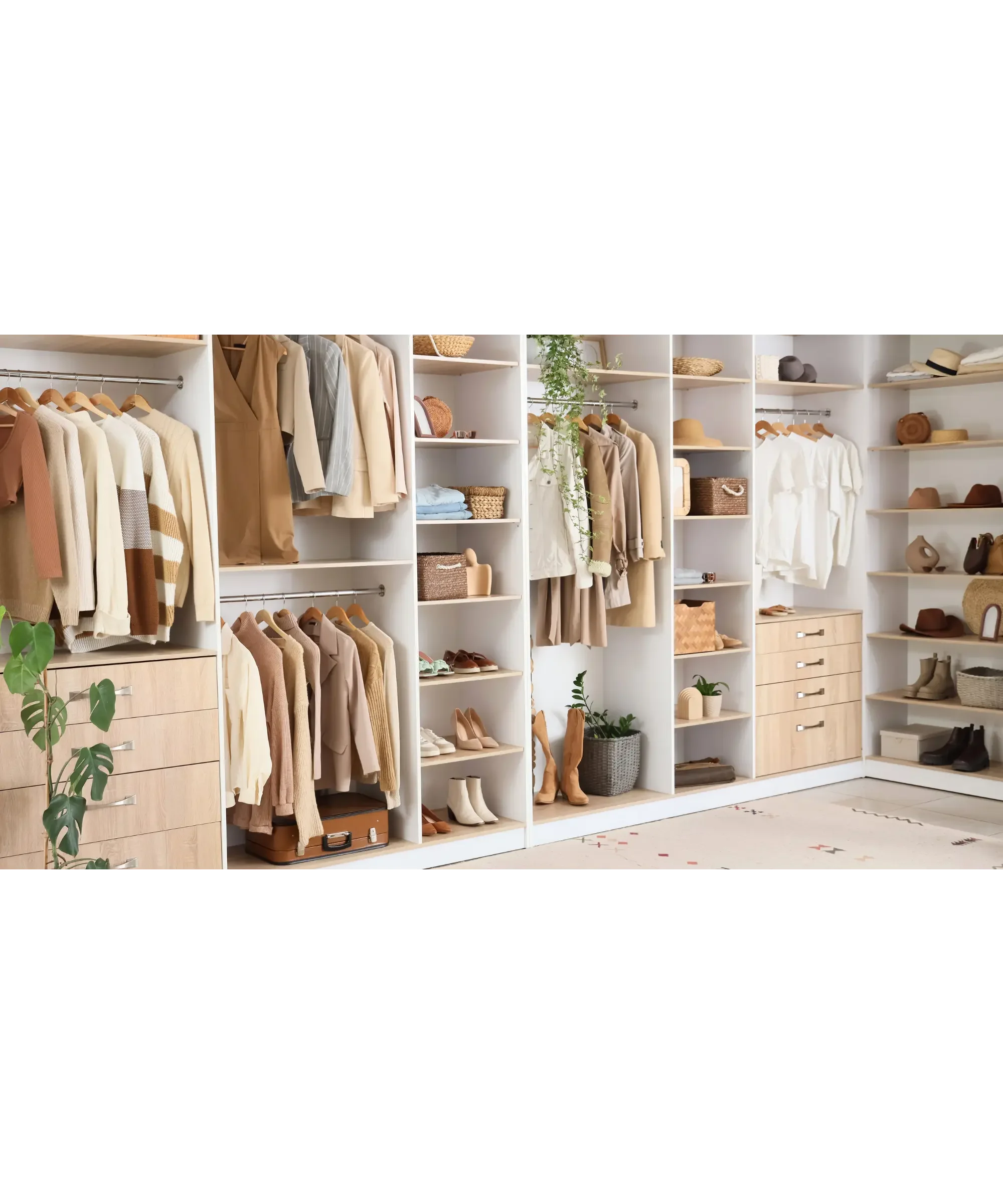 Neatly organized walk-in closet with neutral-toned clothing, shoes, and accessories arranged on shelves, racks, and drawers.
