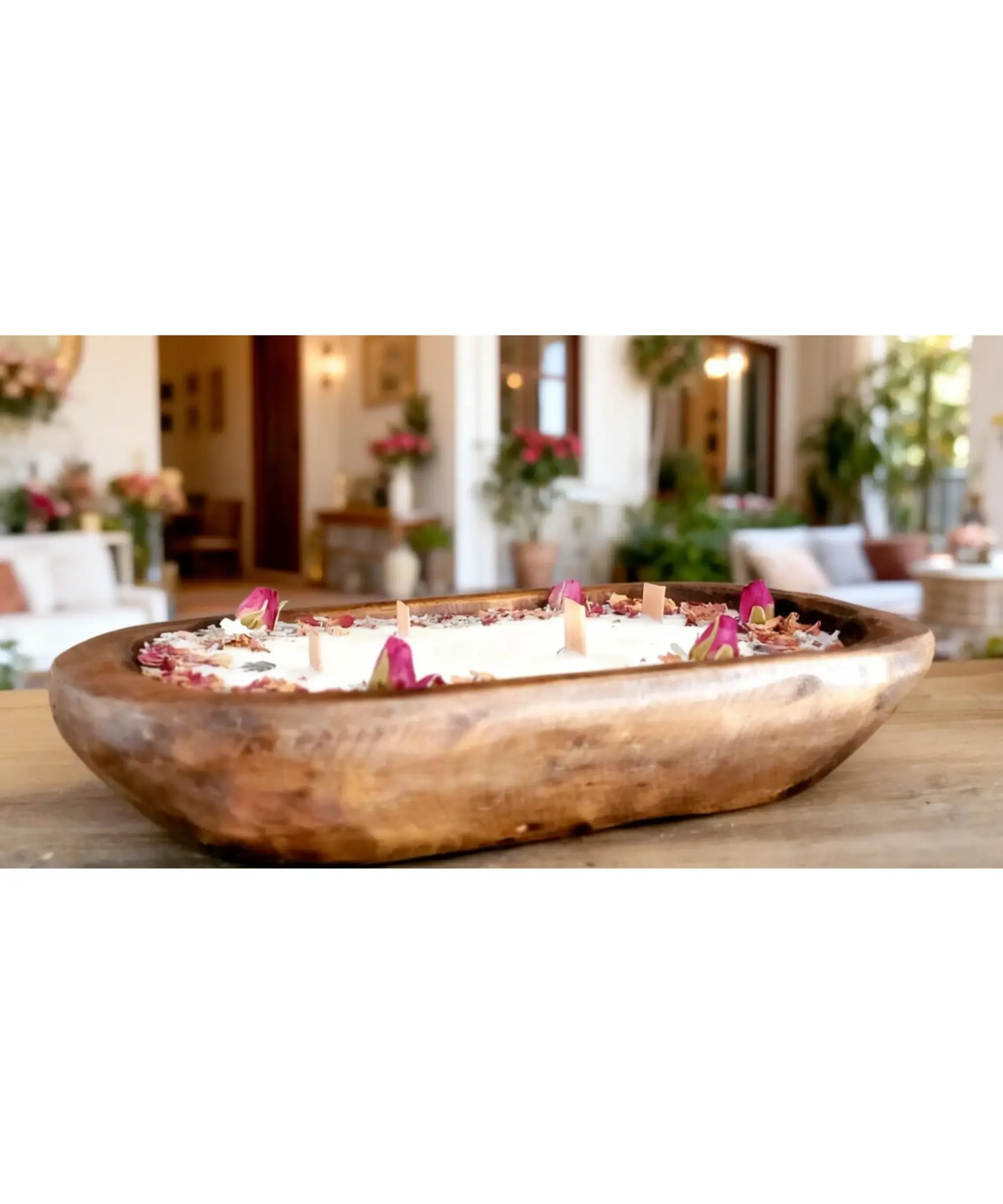 Rustic wood dough bowl candle with soy, coconut, and beeswax blend, wood wicks, and dried flowers displayed on a table in a cozy home setting.