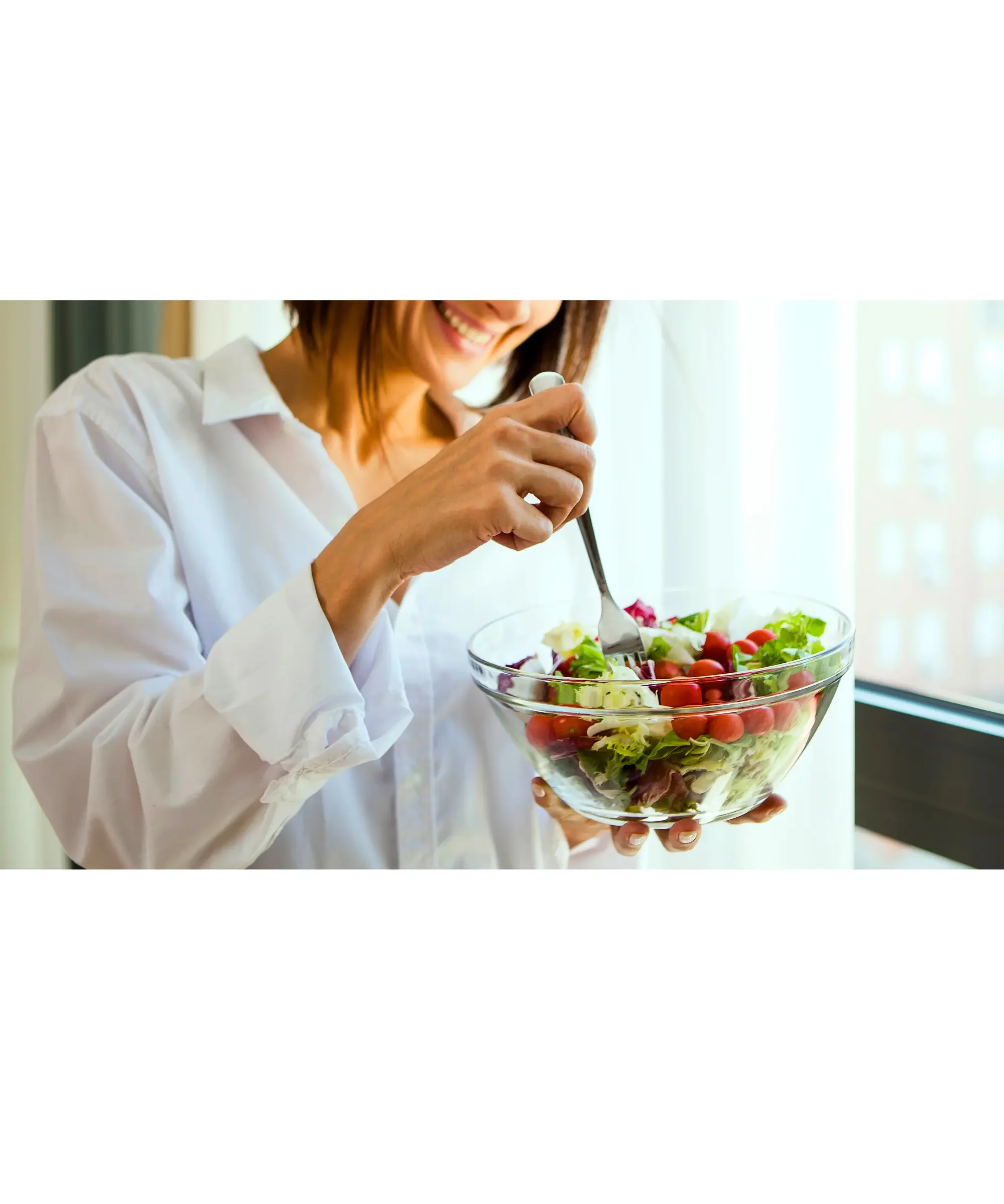 woman eating from a glass jar with healthy salad