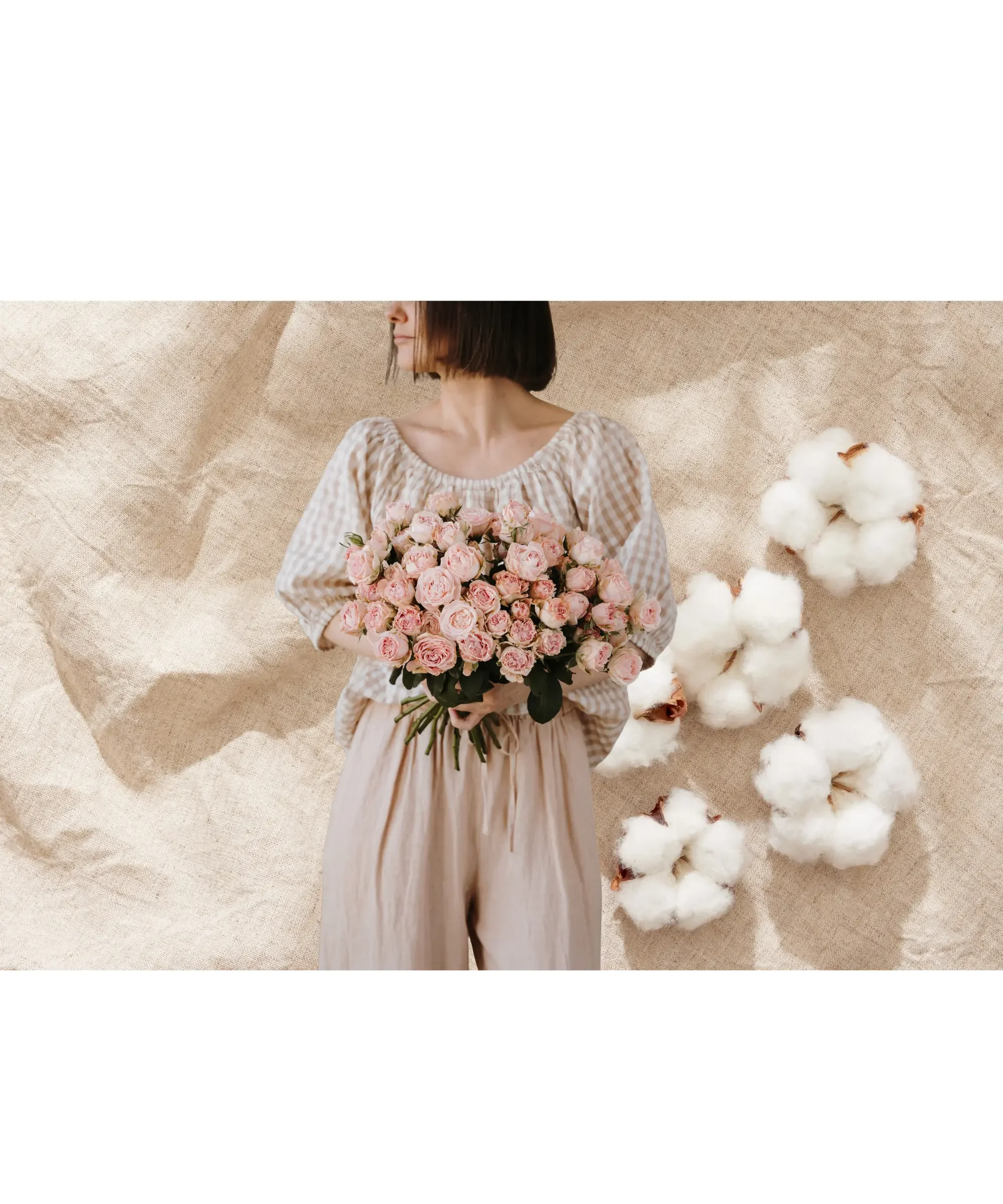 Woman in neutral linen outfit holding bouquet of pink roses with cotton flowers on beige background, minimalist natural style and soft feminine aesthetic