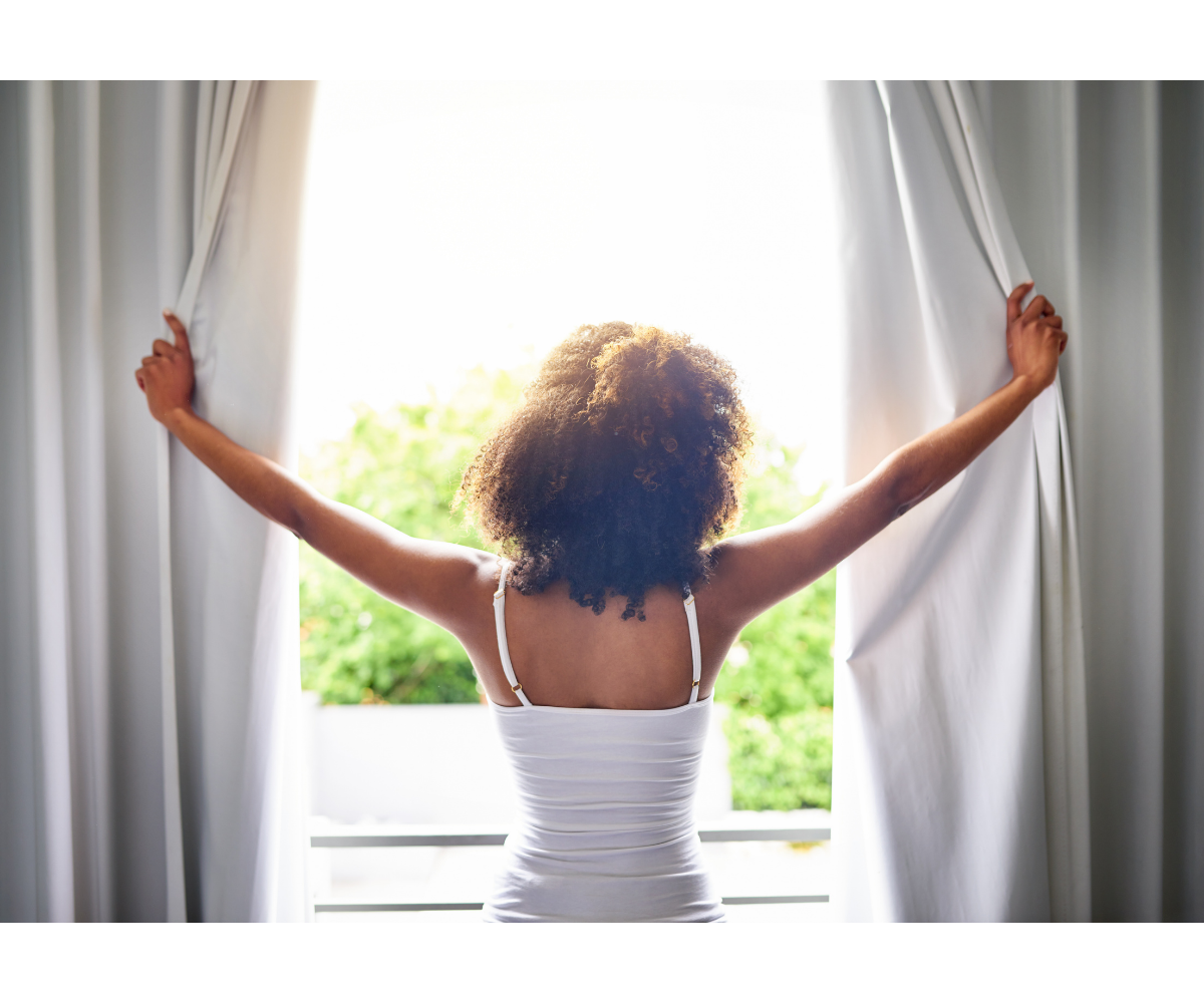 woman opening curtains open