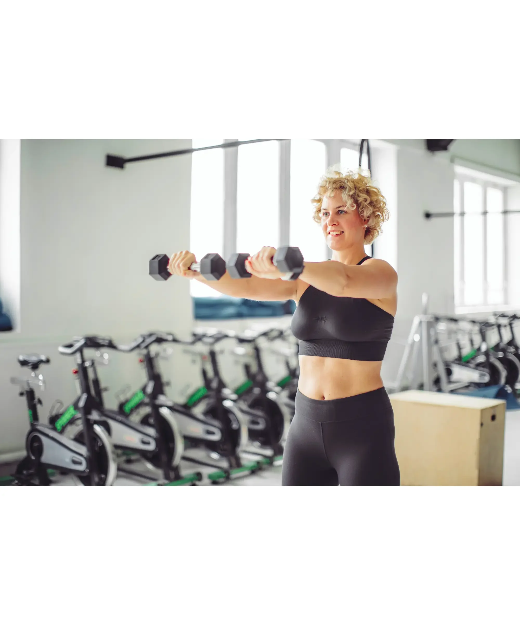 woman holding heavy weights at the gym