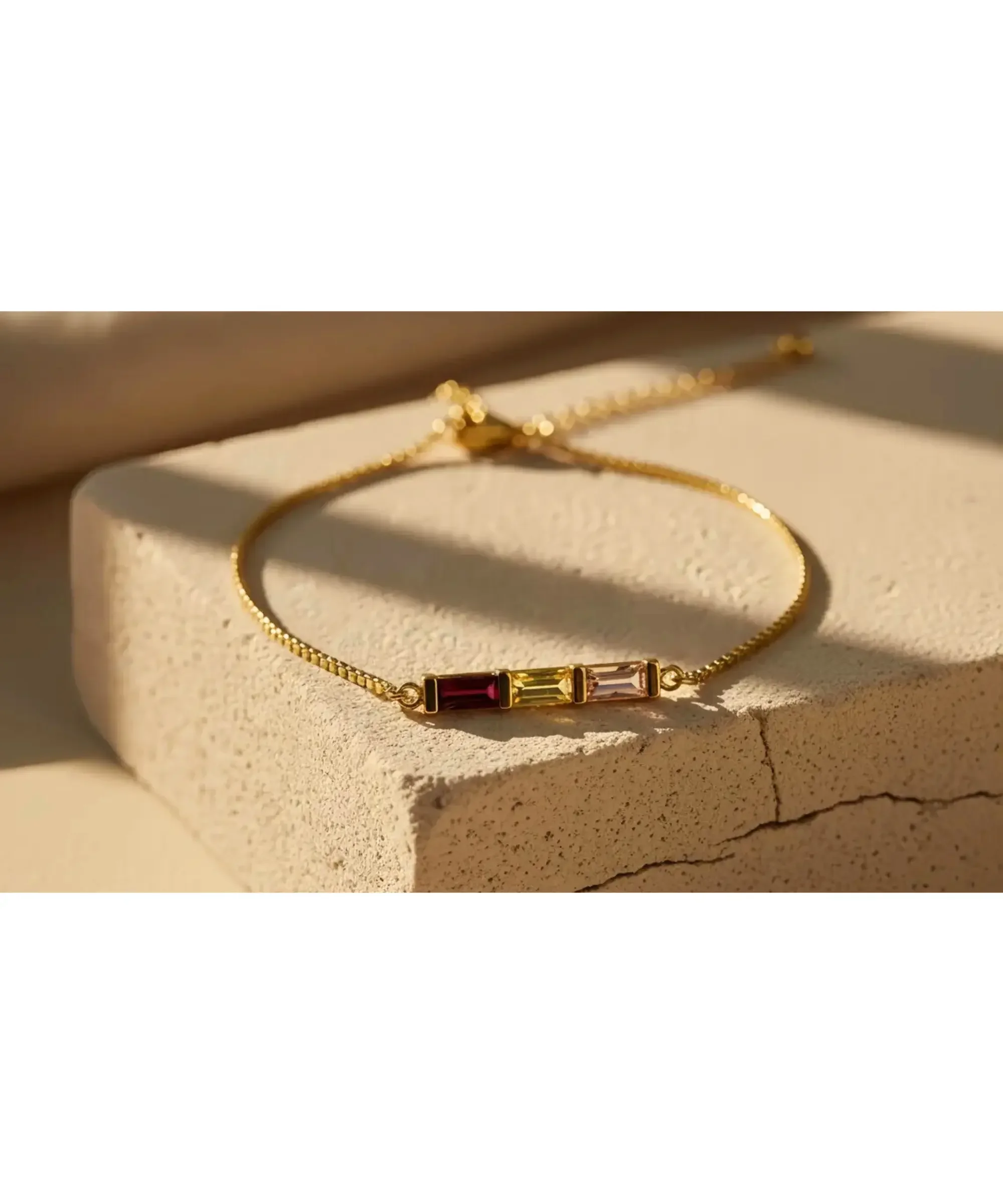 Personalized 14K gold baguette birthstone bracelet with three birthstones on an adjustable chain, meaningful jewelry gift for mom or family.