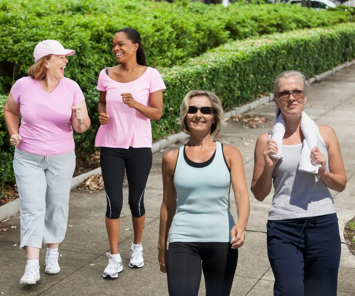 four women walking on a paved trail