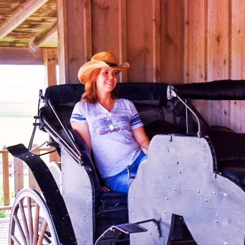 Martrutt founder of Midlife accent sitting in a carriage wearing a cowboy hat