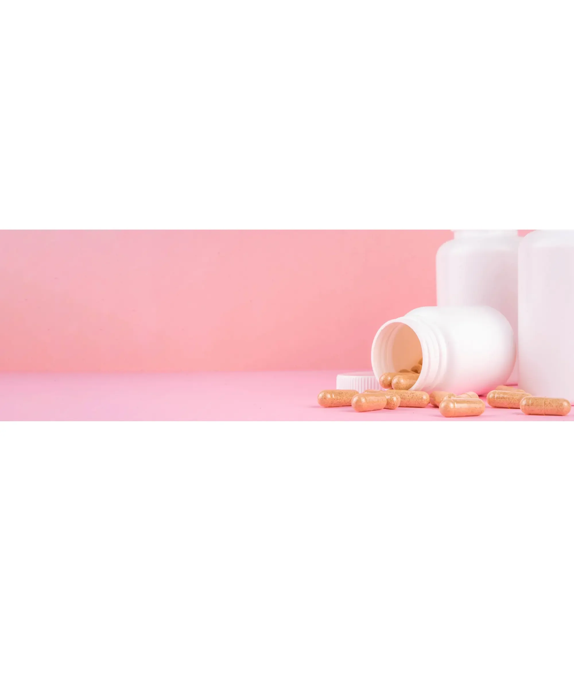 “White pill bottles on a pink background with one bottle tipped over, spilling yellow capsules across the surface.”