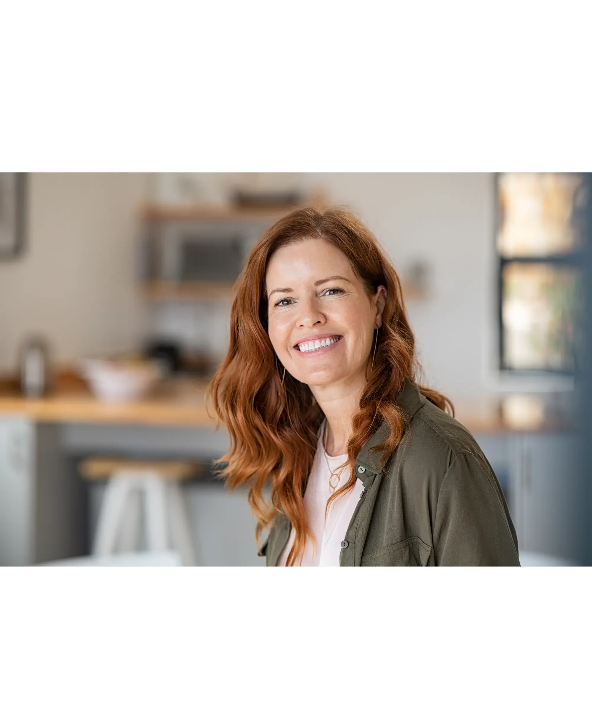 Red hair woman smiling with a kitchen background