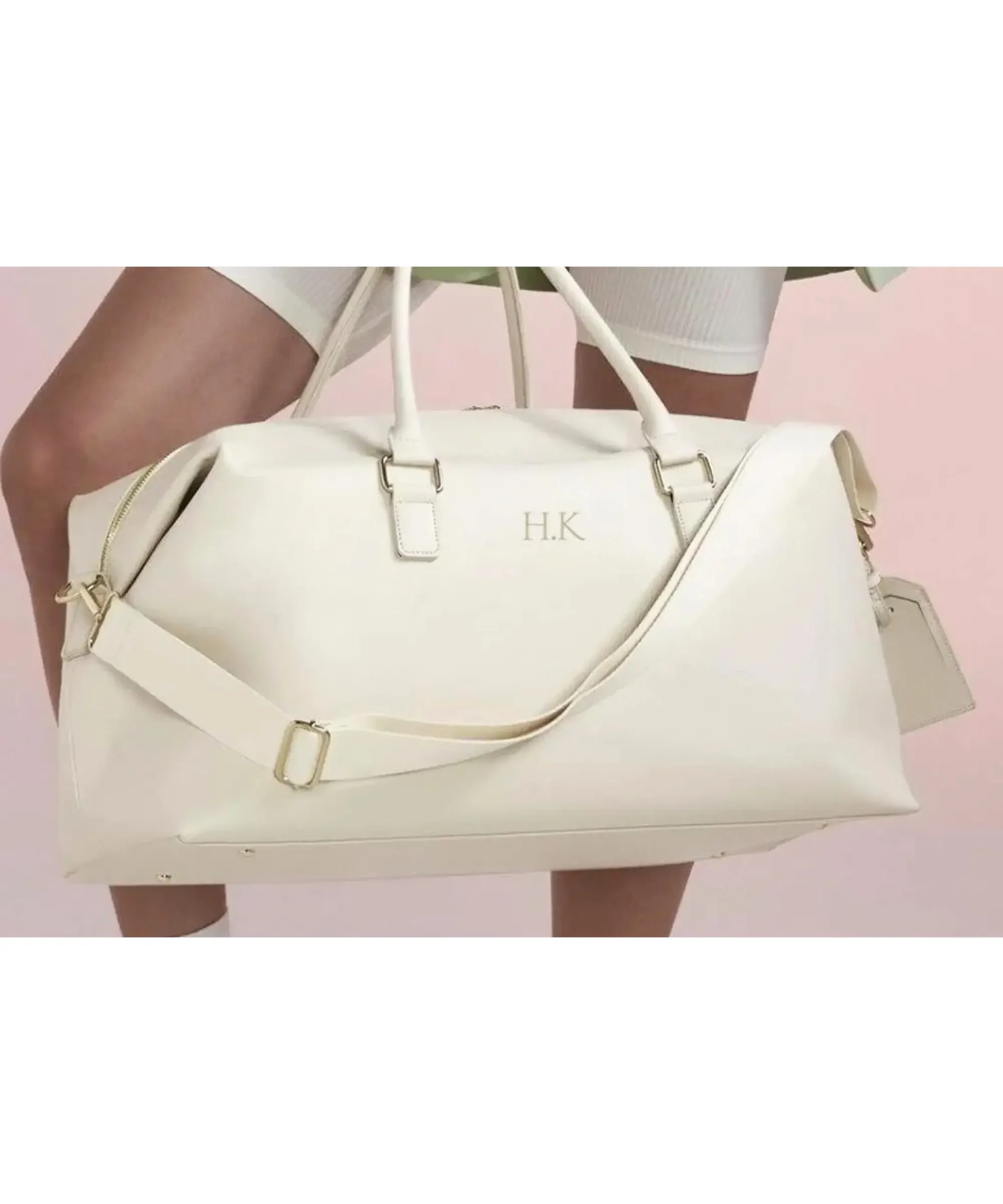 Personalized white leather weekender bag with gold "HKL" monogram, sturdy handles, and luggage tag—luxury travel tote for modern women.