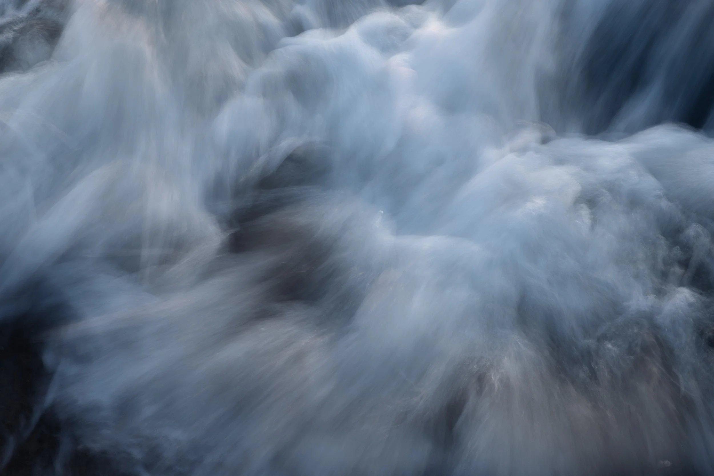 Verschwommene Bewegungen von Wasserwellen in Blautönen.