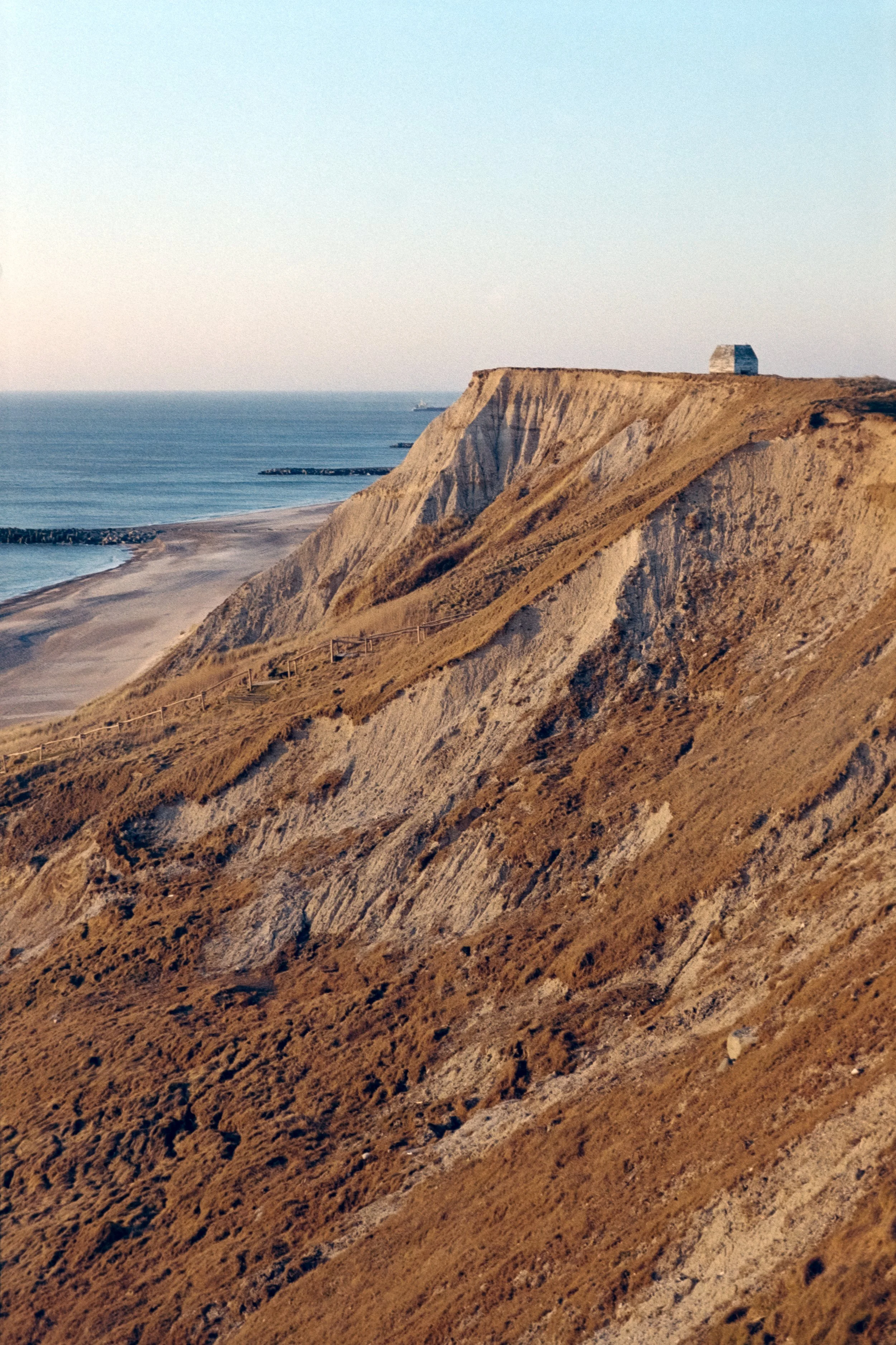 Auf diesem analogen Foto ist eine Steilküste in Dänemark zu sehen, auf der sich ein alter Bunker befindet.