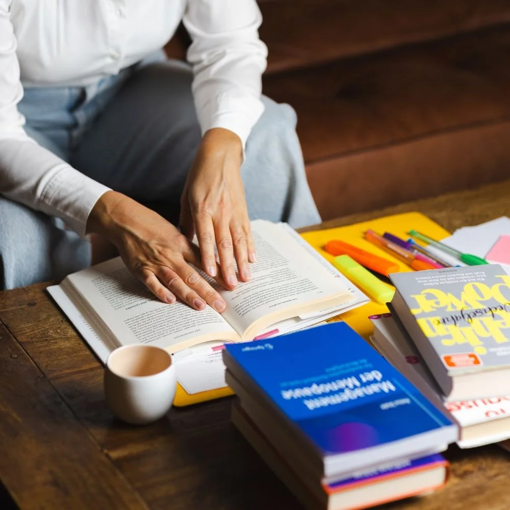 Nahaufnahme von Händen die für die Ausbildung zur Wechseljahresberater:in lernen. Literatur zu Wechseljahren