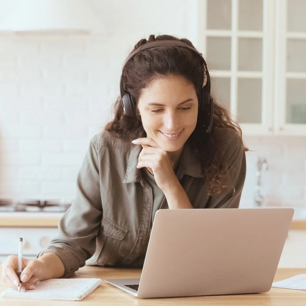Frau in heller Küche nimmt an MenoCert-Webinar teil