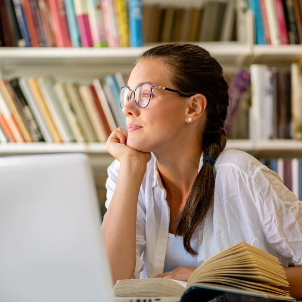 Konzentriertes Lernen mit Buch und Laptop – symbolisiert ein klar aufgebautes Lernkonzept zur Wechseljahresberatung