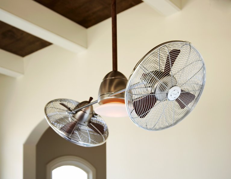 Ceiling fan with two blades and a light installed on a ceiling in a room with beige walls.