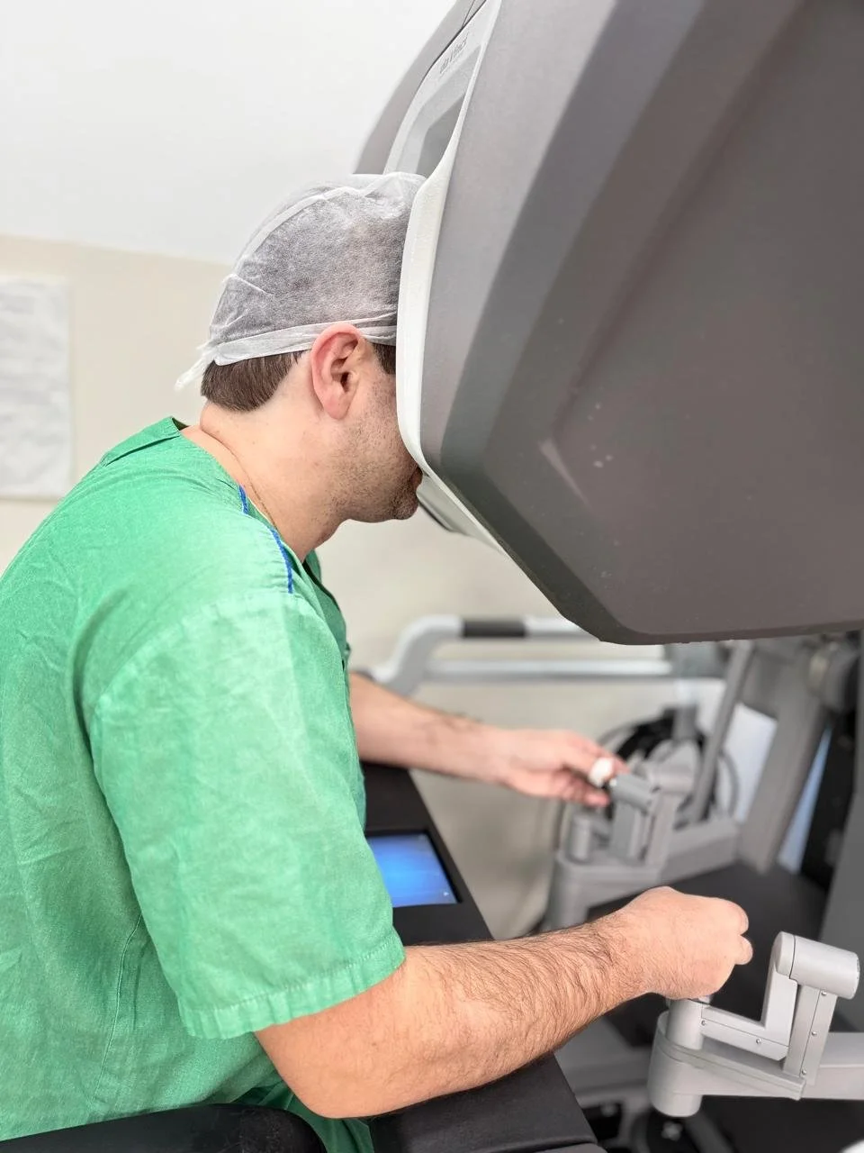 Profissional de saúde usando equipamento médico de ressonância magnética com capacete de proteção, em ambiente clínico.