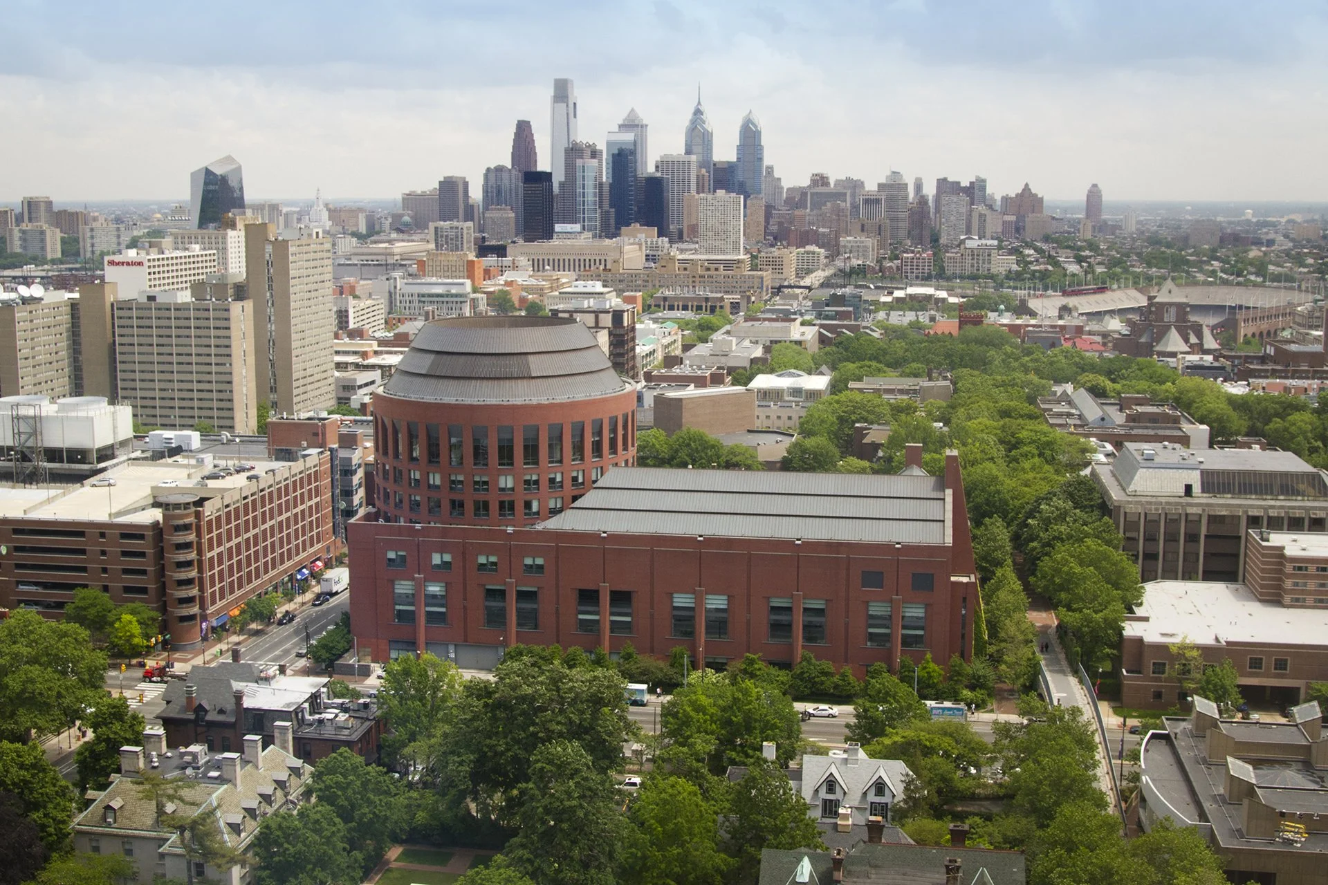 Wharton’s Huntsman Hall at the University of Pennsylvania, with the Philadelphia skyline in the background.