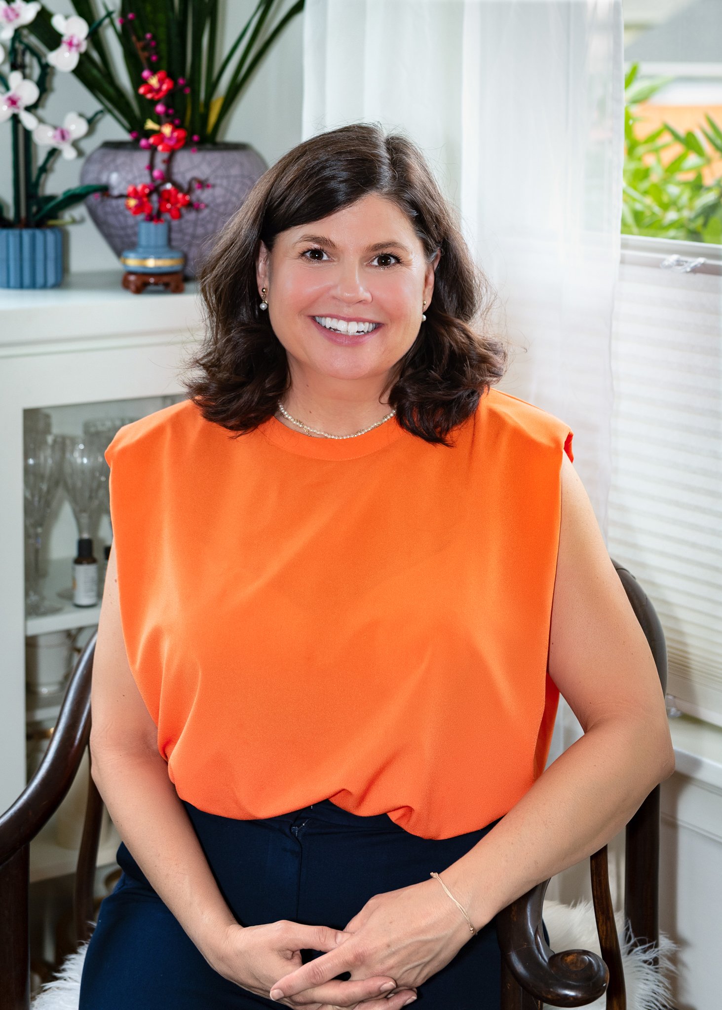 Charli Taylor, founder of EduVentura, seated in an orange top.