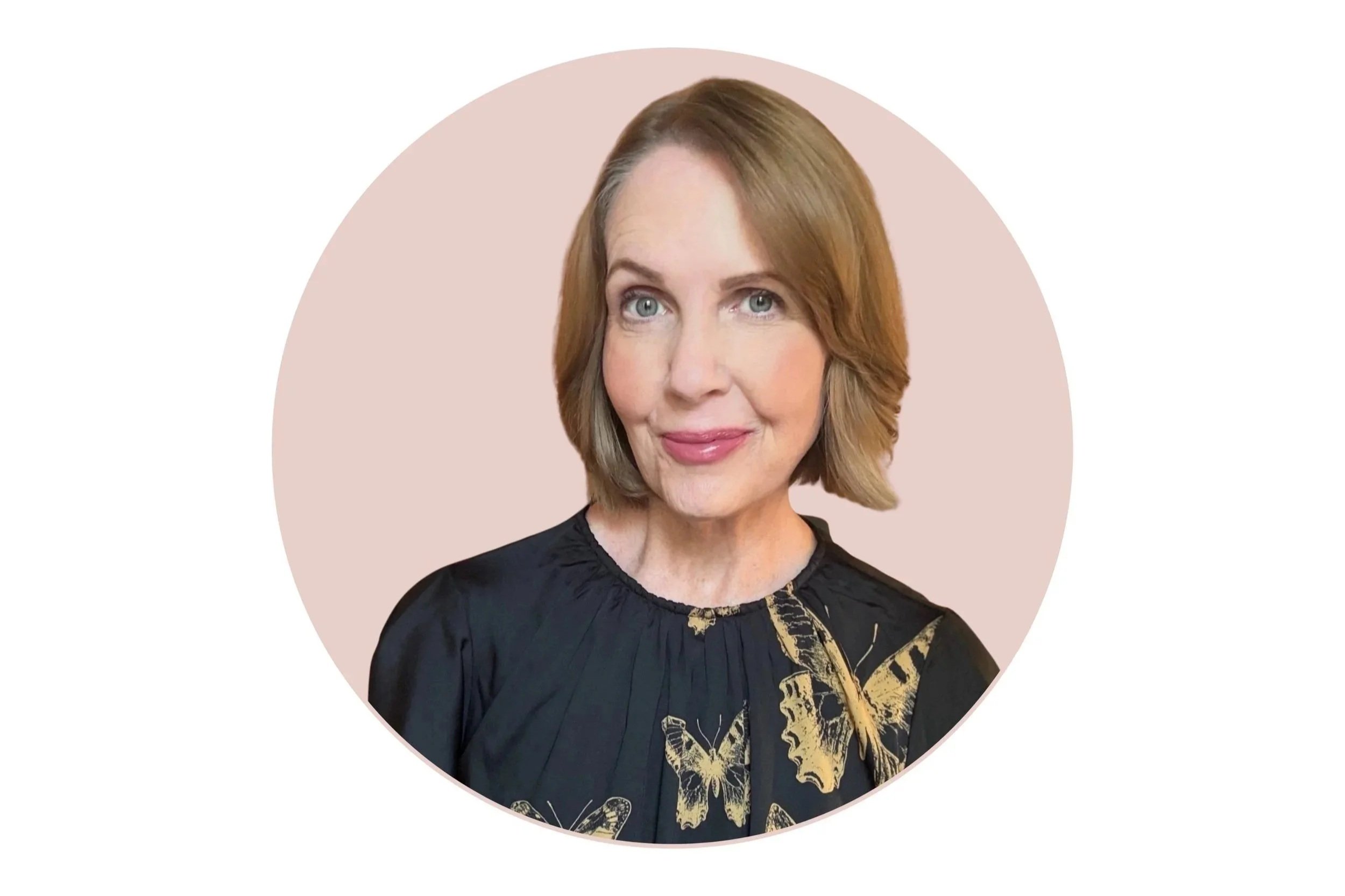 The image is Lori Massicot wearing a black blouse with gold butterflies smiling looking at the camera. The background of the image is rose pink.