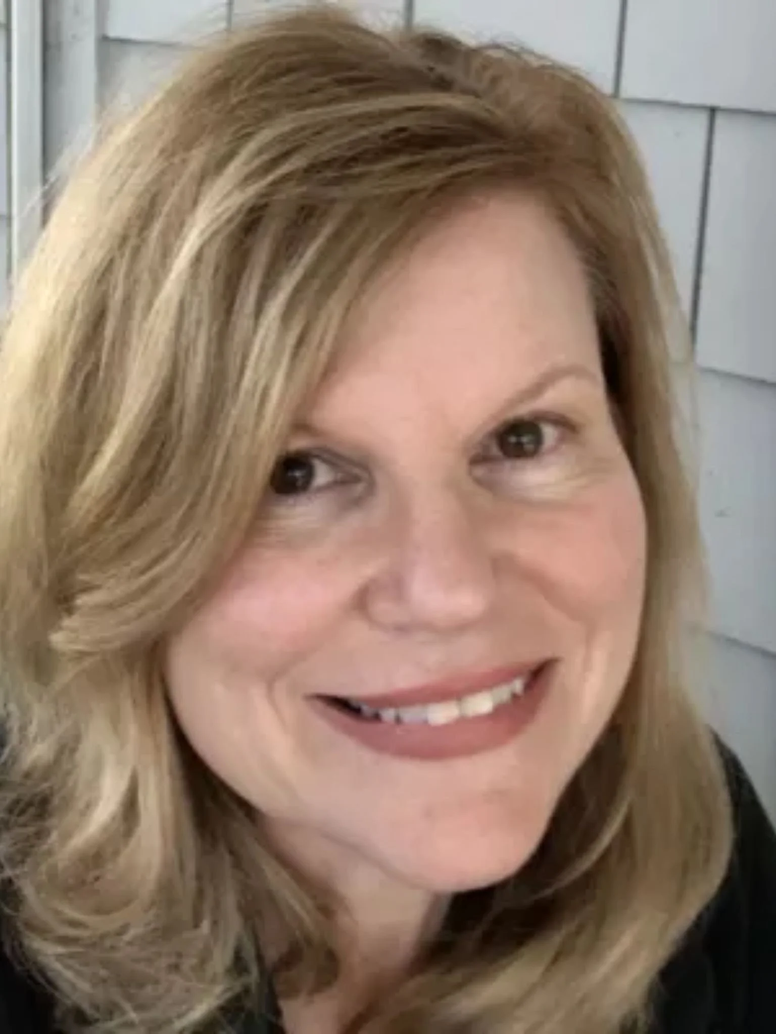 This is an image of Donna Ferris, the host of the Bounce Back Stronger podcast looking at the camera smiling. She has brown hair and brown eyes.